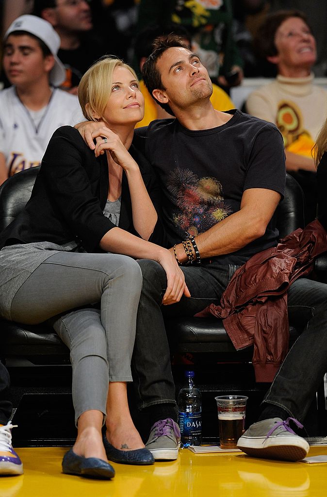 Charlize Theron and Stuart Townsend watch the season opening game  | Getty Images