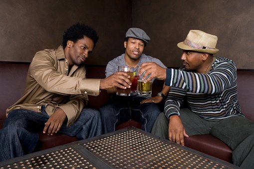 Photo of African friends toasting with beer in nightclub | Photo: Getty Images