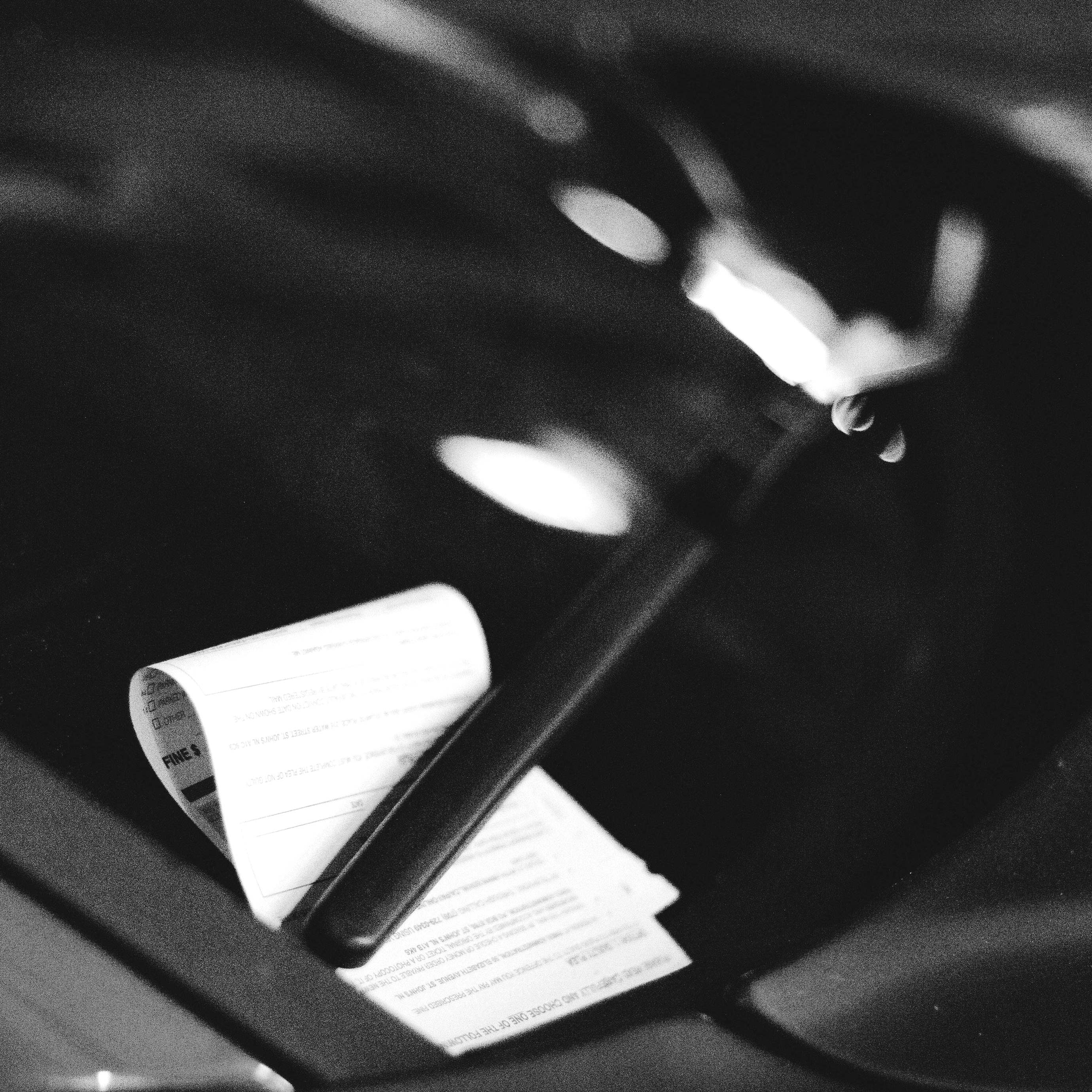 An official notice tucked under the windscreen wiper of a car | Source: Pexels