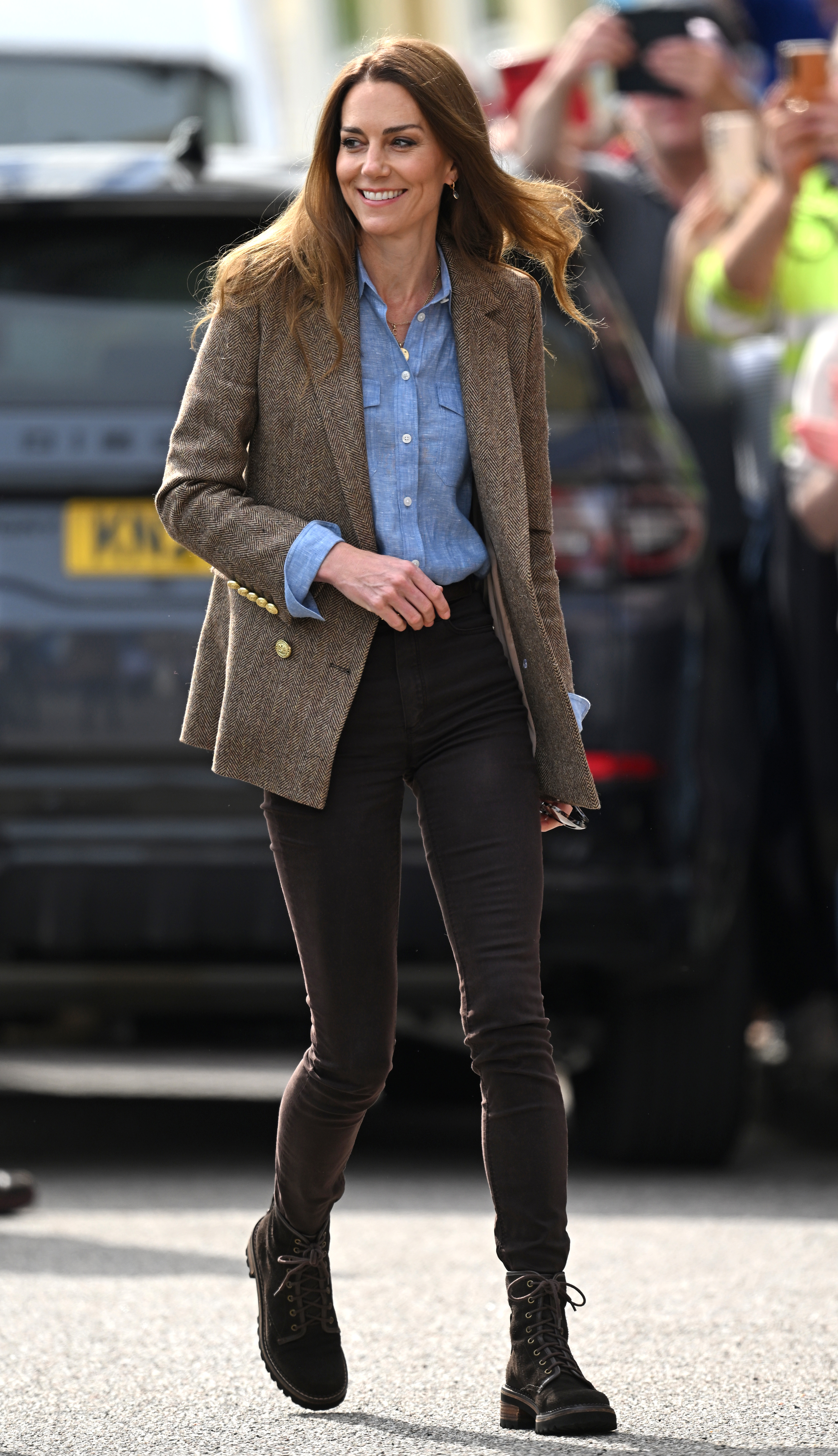 Wearing fitted brown pants, a blue shirt, and her signature loose waves, Catherine steps out to meet members of the public in Tobermory. Her choice of outfit drew a wave of online responses, making it a talking point during the royal tour.