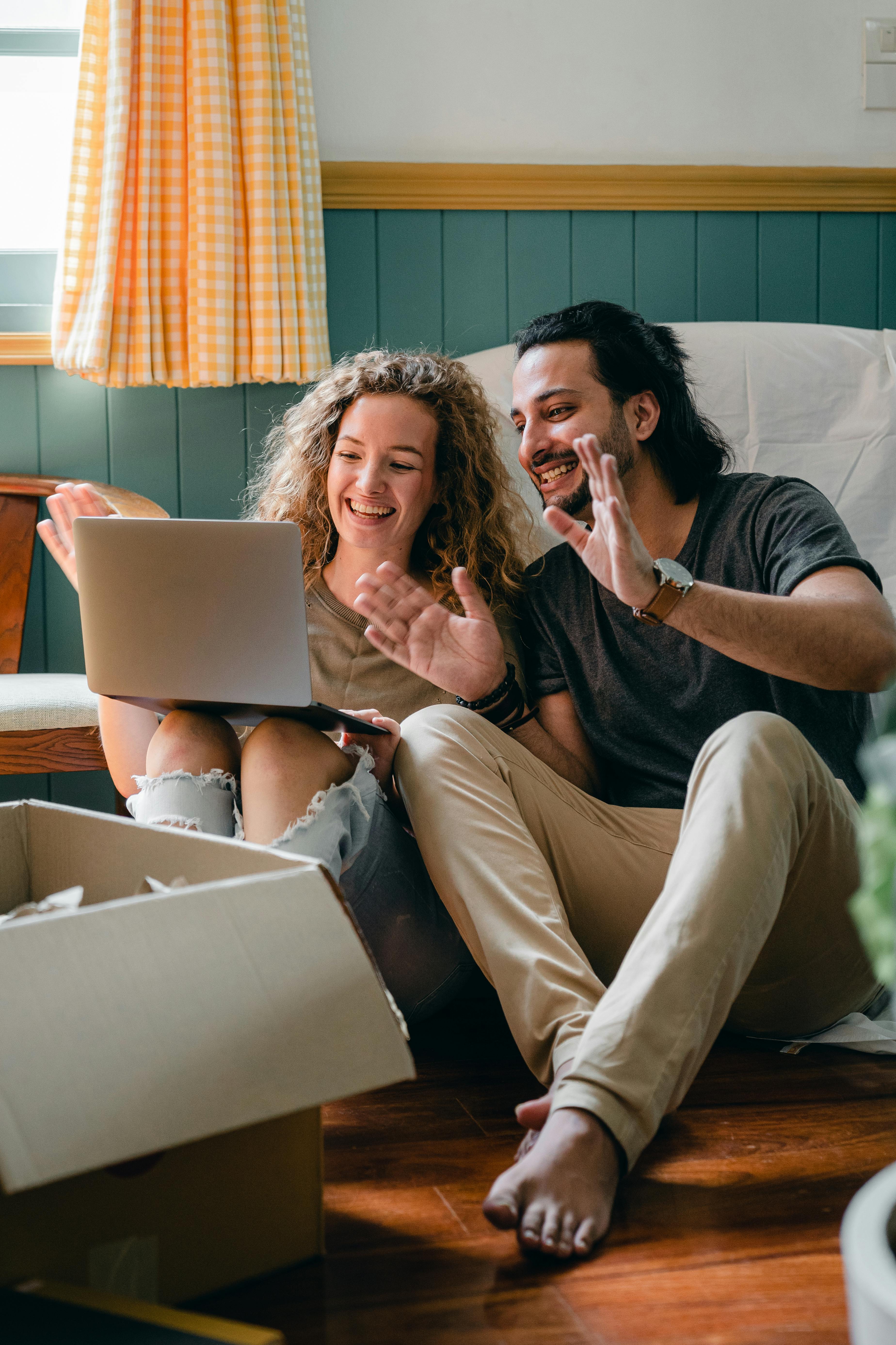 A happy couple looking at something on a laptop | Source: Pexels