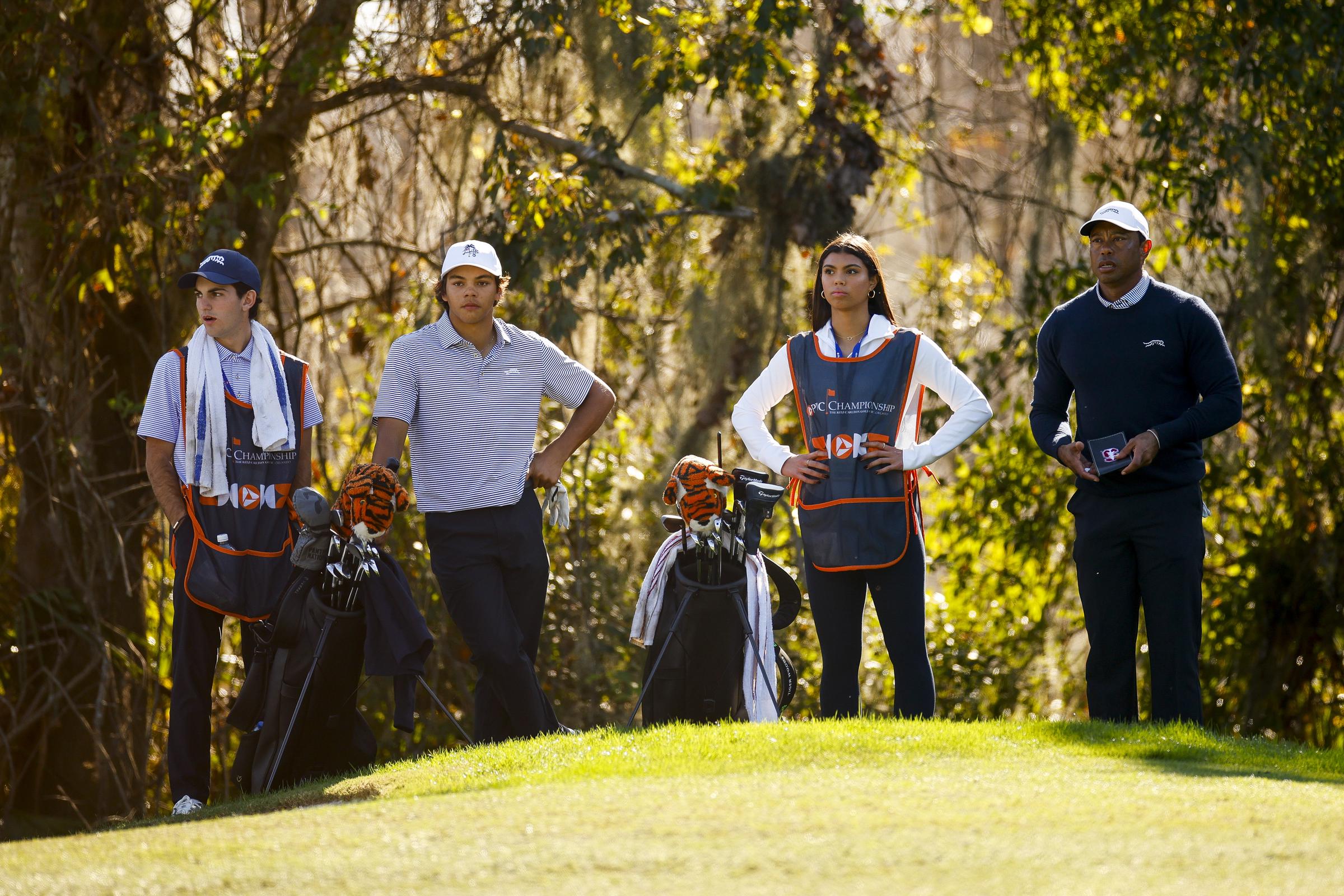 Luke Wise, Charlie, Sam, and Tiger Woods look on while playing the 13th hole during the first round of the PNC Championship | Source: Getty Images