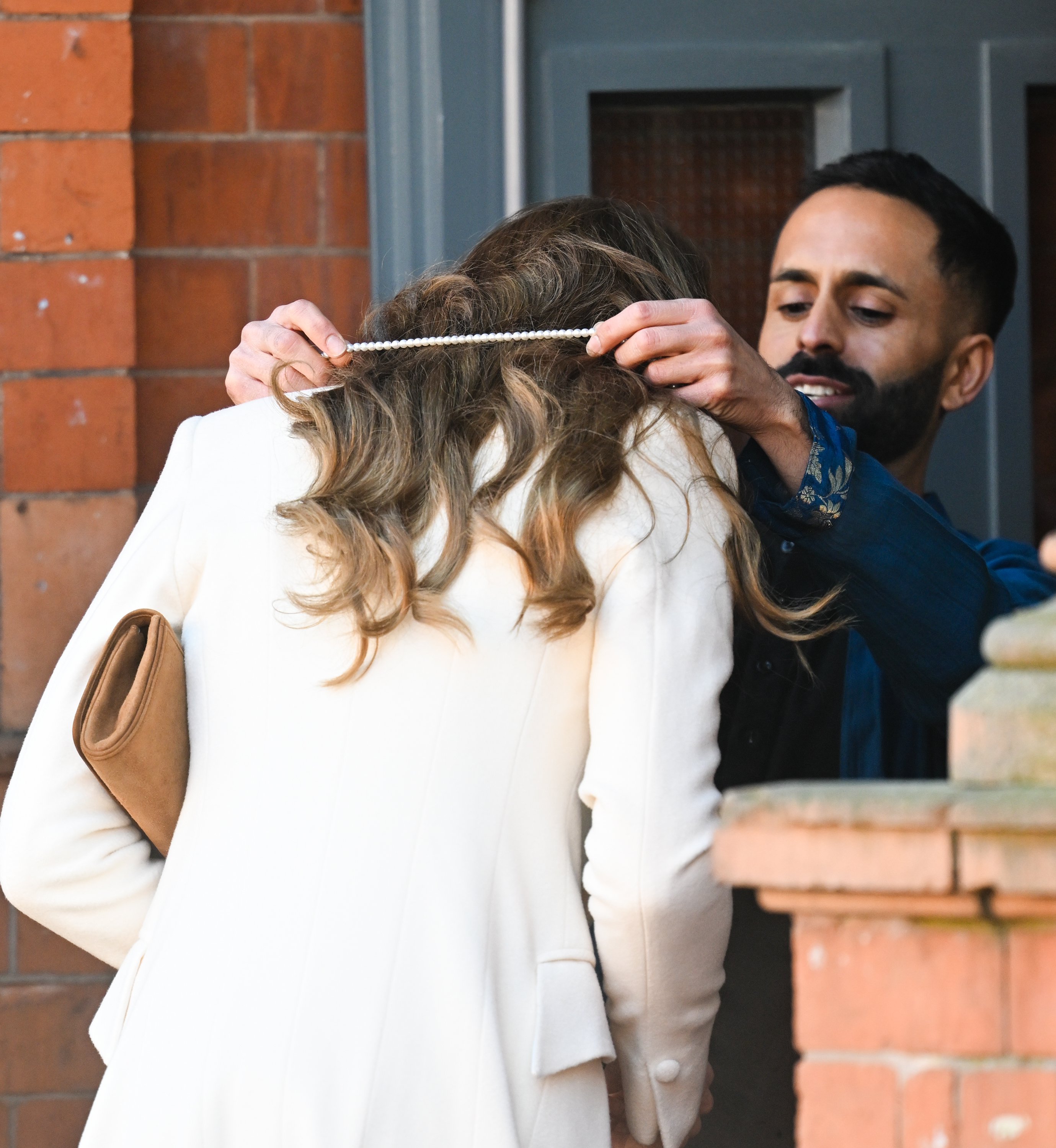 Catherine, Princess of Wales, bows her head slightly as a host places a delicate garland around her neck upon arrival at the Aakash Odedra Company in Leicester on March 5, 2026. The welcoming gesture, offered as she stepped inside the building, formed part of the traditional greeting extended to the Princess of Wales at the start of her visit celebrating dance, culture, and the local community.