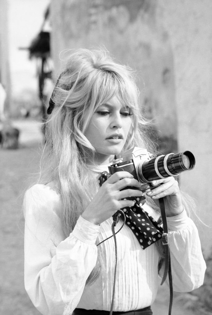 L'actrice française Brigitte Bardot tient un appareil photo pendant une pause dans le tournage du film 'Viva Maria' (réalisé par Louis Malle), Texcoco, Mexique, février 1965. | Photo : Getty Images L'actrice française Brigitte Bardot tient un appareil photo pendant une pause dans le tournage du film 'Viva Maria' (réalisé par Louis Malle), Texcoco, Mexique, février 1965. | Photo : Getty Images