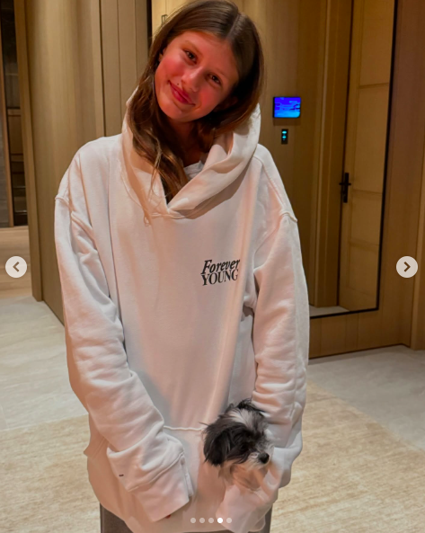 Vivian Brady posing for a photo with a puppy in her pocket. | Source: Instagram/tombrady