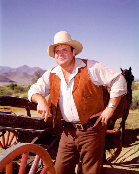 US actor Dan Blocker in costume as he leans against a cart. | Source: Getty Images