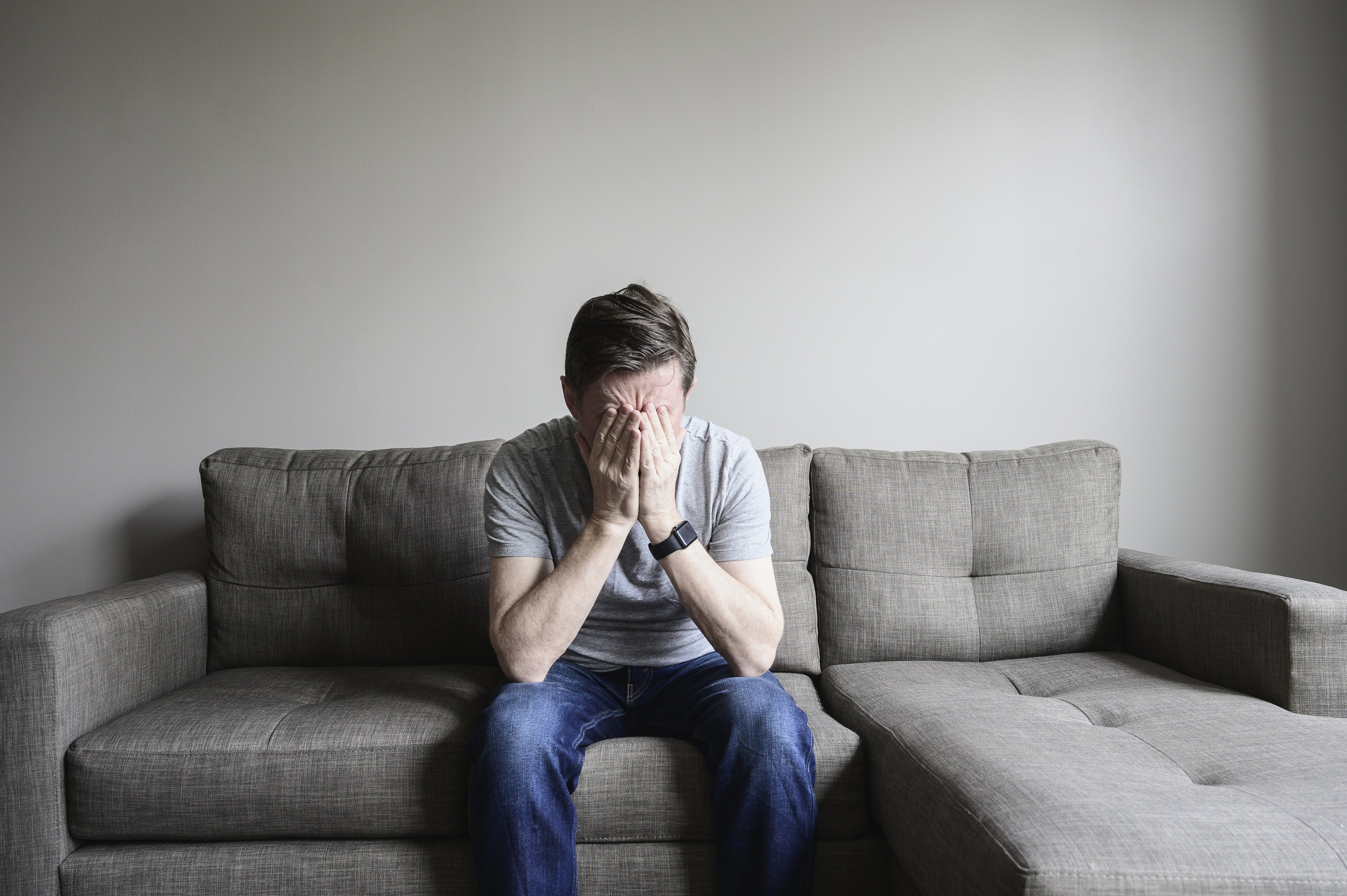 Depressiver reifer Mann sitzt auf der Couch I Quelle: Getty Images