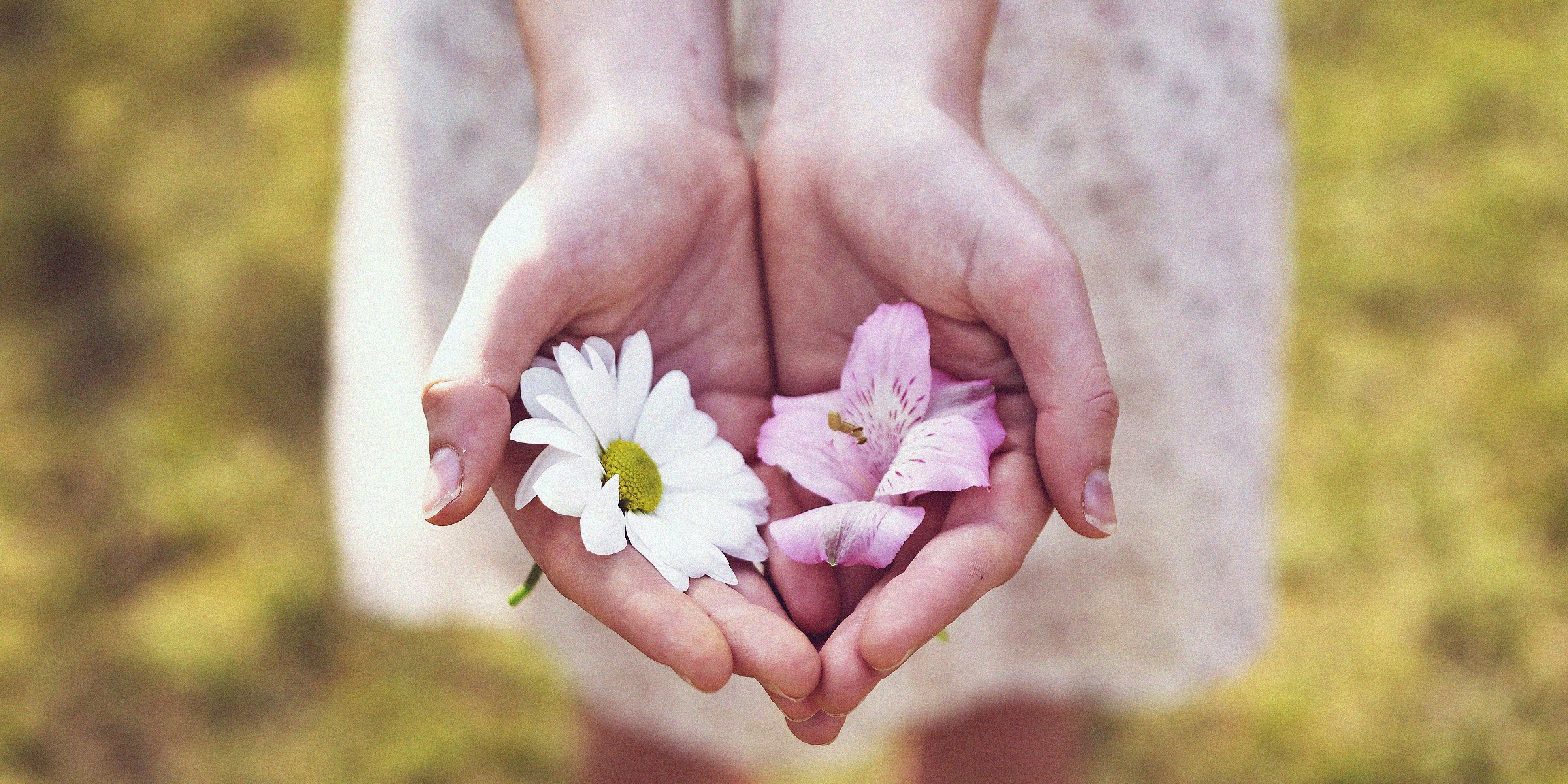 A woman holding flowers in her palms. | Source: Unsplash