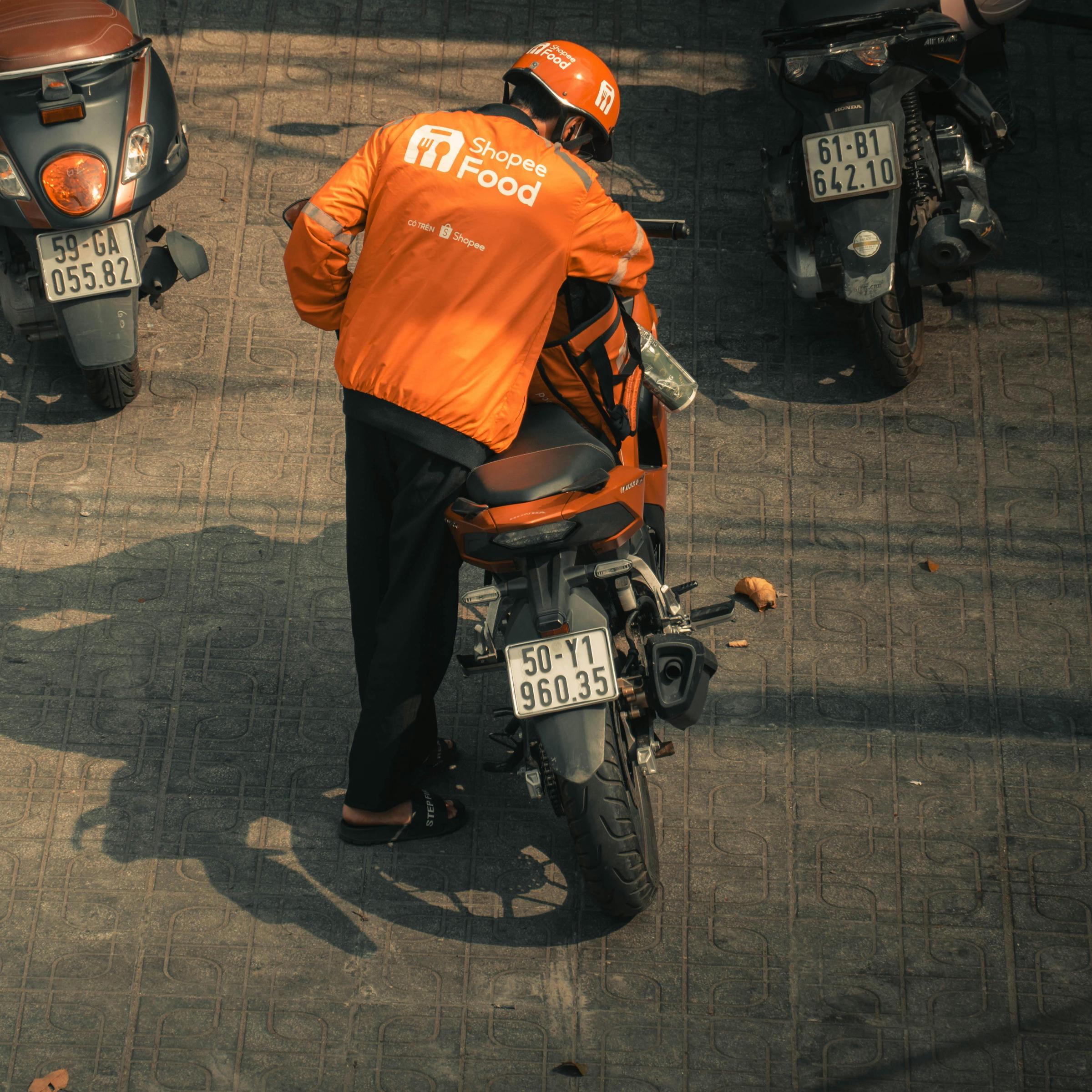 A food delivery man saddling up on his motorcycle | Source: Pexels