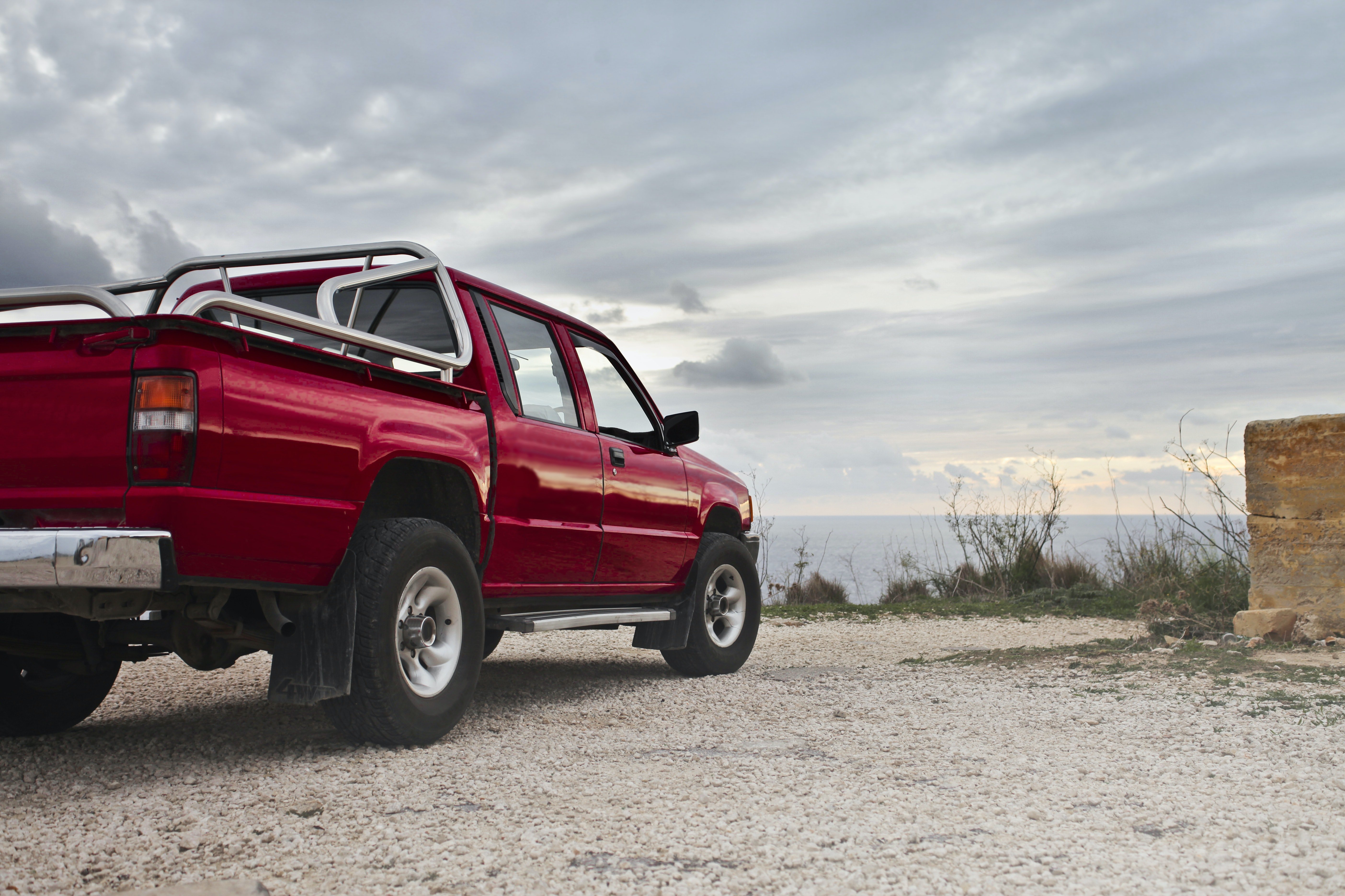 A red pick-up truck parked by the side of the road | Source: Pexels