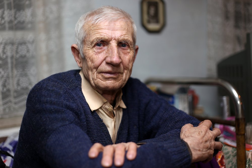 Retrato de hombre mayor sentado en casa. Fuente: Shutterstock