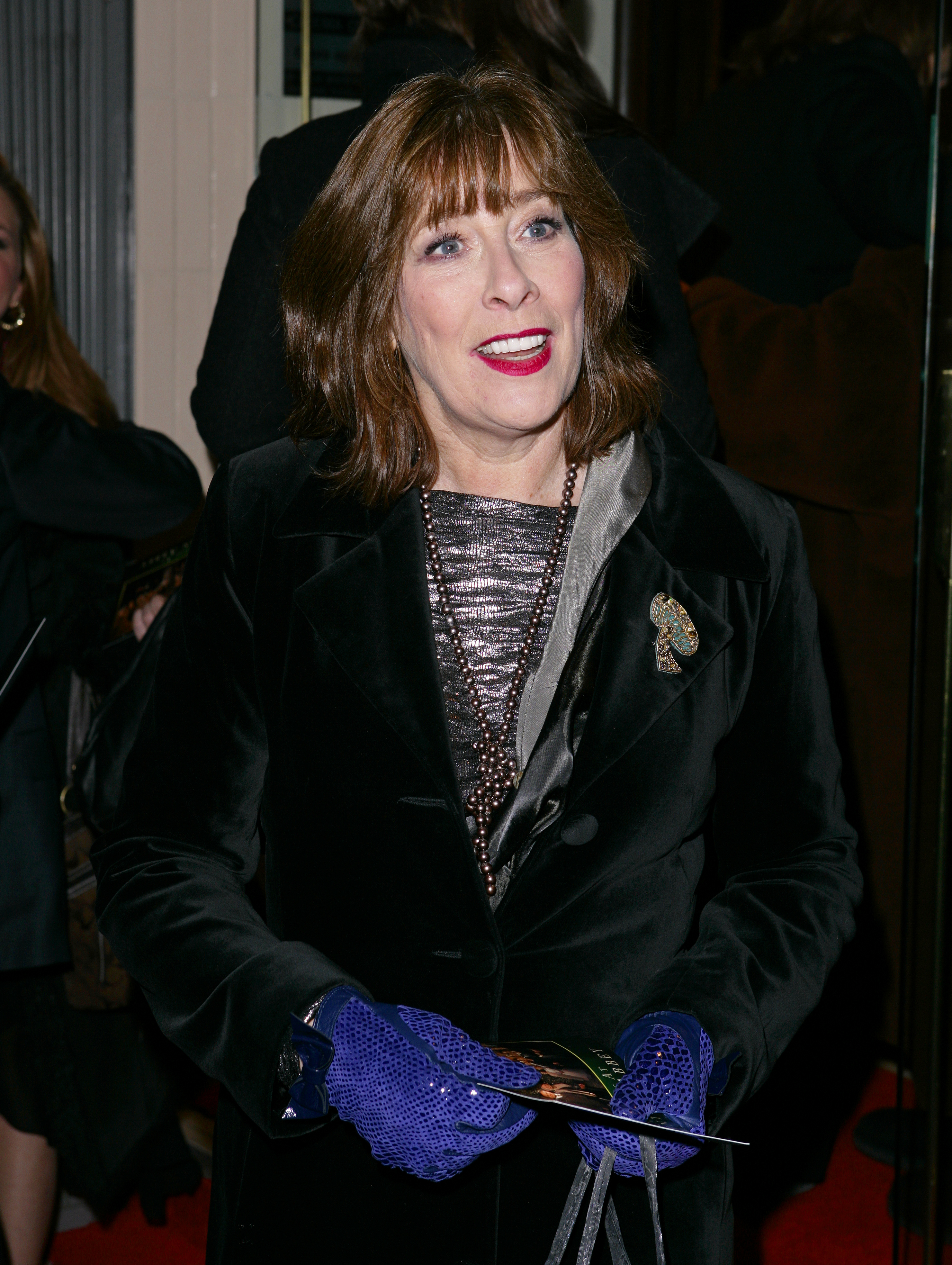 Phyllis Logan attended the 2011 screening of "Christmas at Downton Abbey" in a black velvet coat over a metallic dress, accessorized with statement gloves and pearls. With her warm smile and voluminous auburn hair, she exuded charm while keeping things classic and festive.