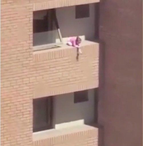 La niña de dos años fue vista jugando en la cornisa de un cuarto piso de un edificio, sin rejas ni barandas. Fuente: YouTube / Entertainment is Fun