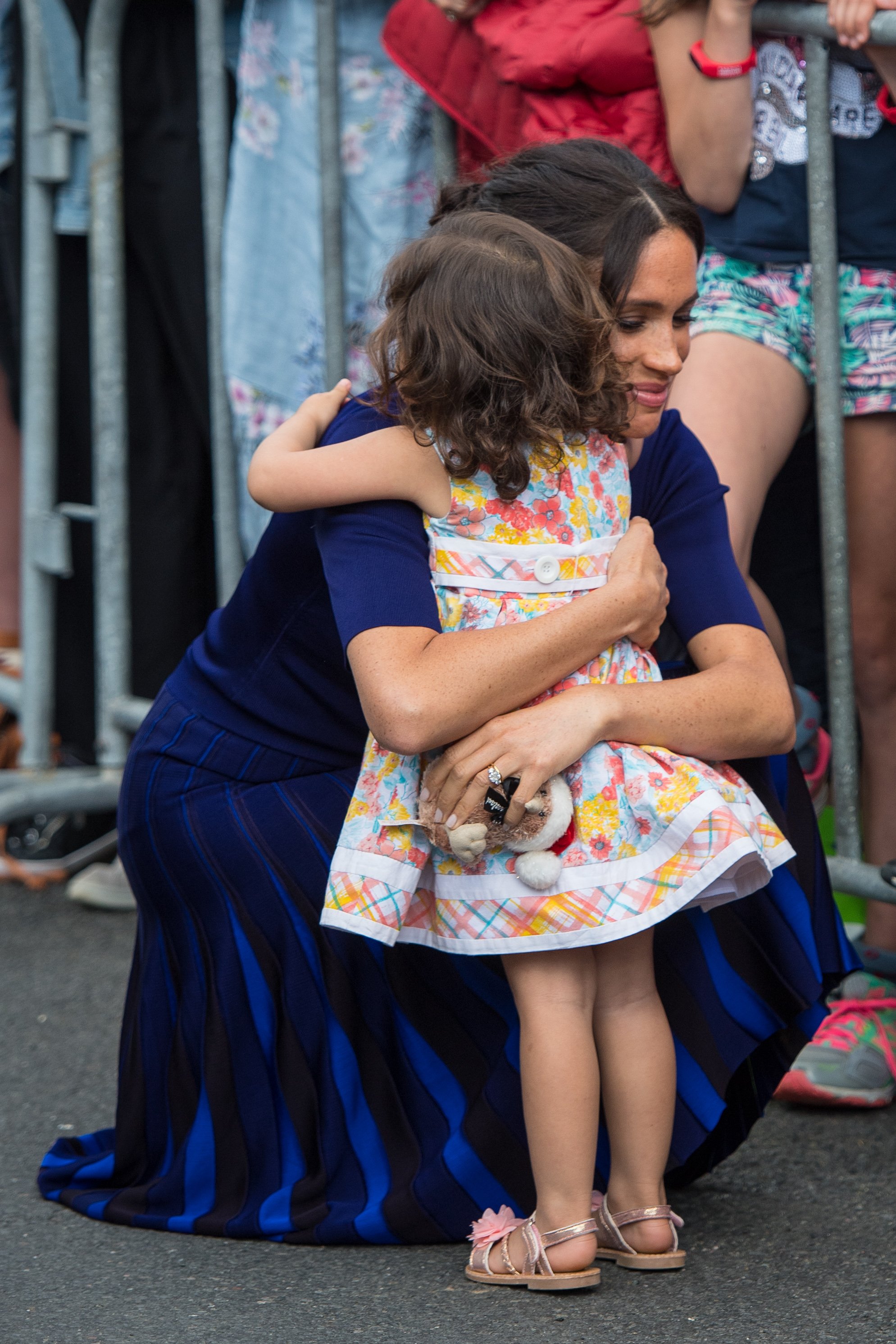 Megan, Duchess of Sussex hugs a young girl during a walkabout on day four of the royal couple's tour of New Zealand on October 31, 2018. | Source: Getty Images