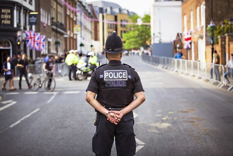 Un policier tournant le dos au caméras | Photo / Unsplash Un policier tournant le dos au caméras | Photo / Unsplash