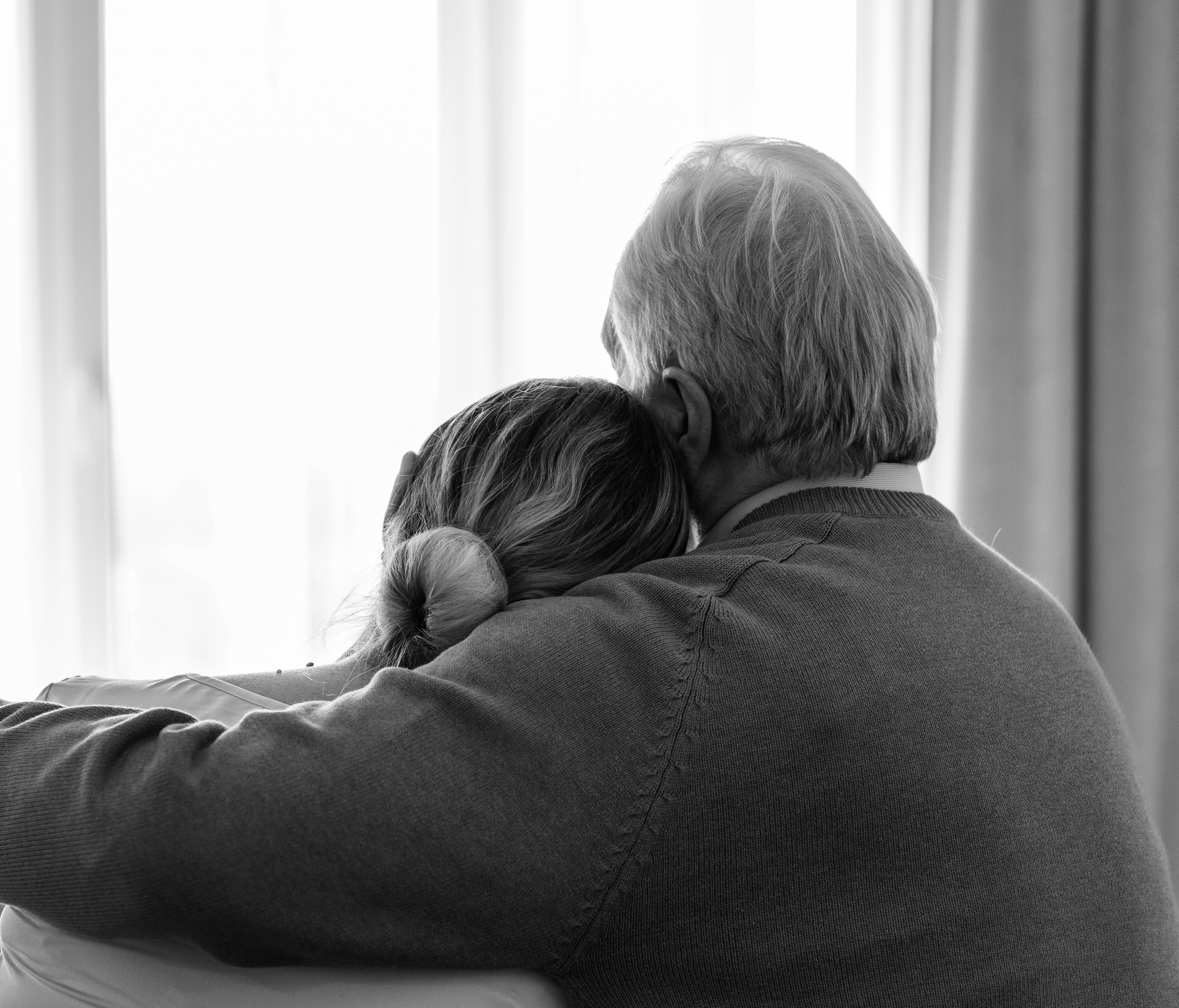 A woman resting her head on an older man's shoulder | Photo: Pexels