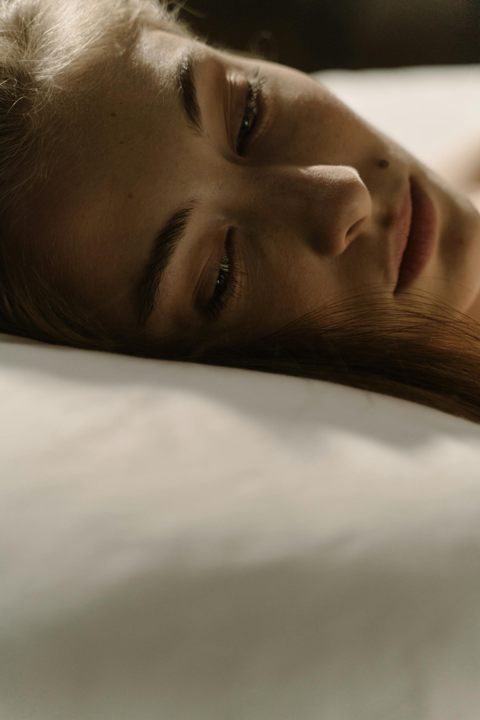 A woman lying awake in bed | Source: Pexels