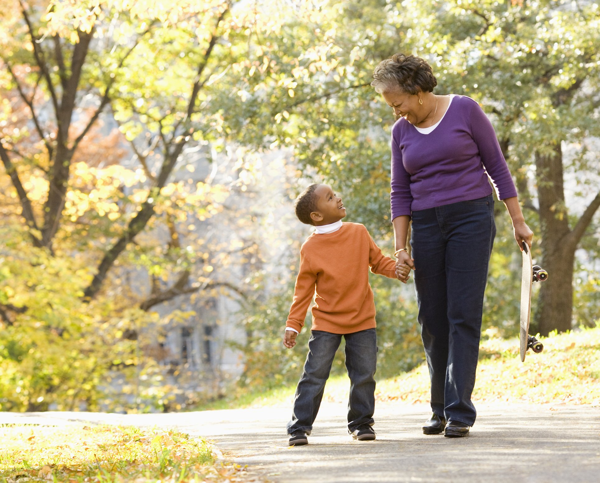 Grandmother and granson walking in park smiling | Photo: Getty Images