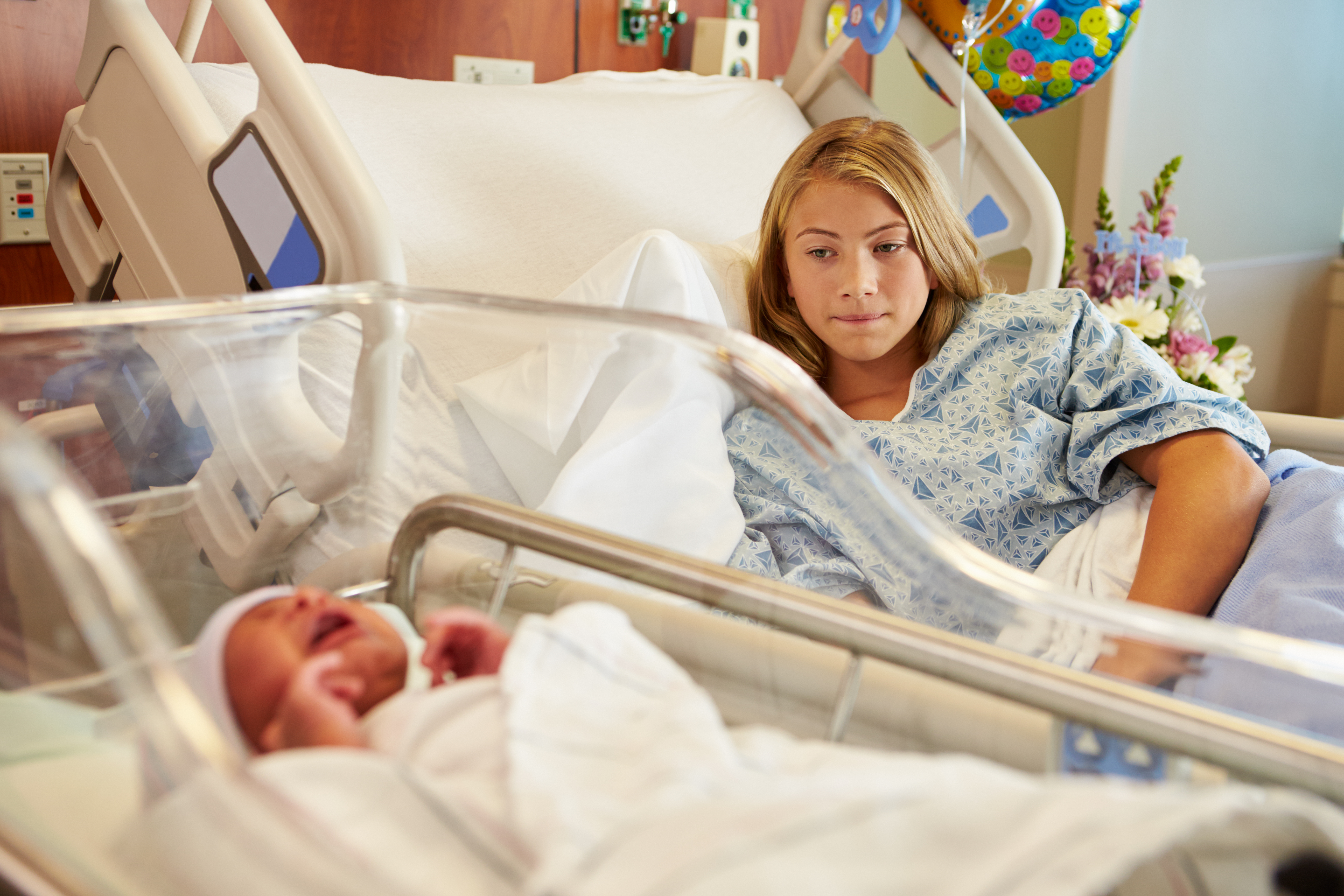 A teenage mother in the hospital with her newborn | Source: Shutterstock