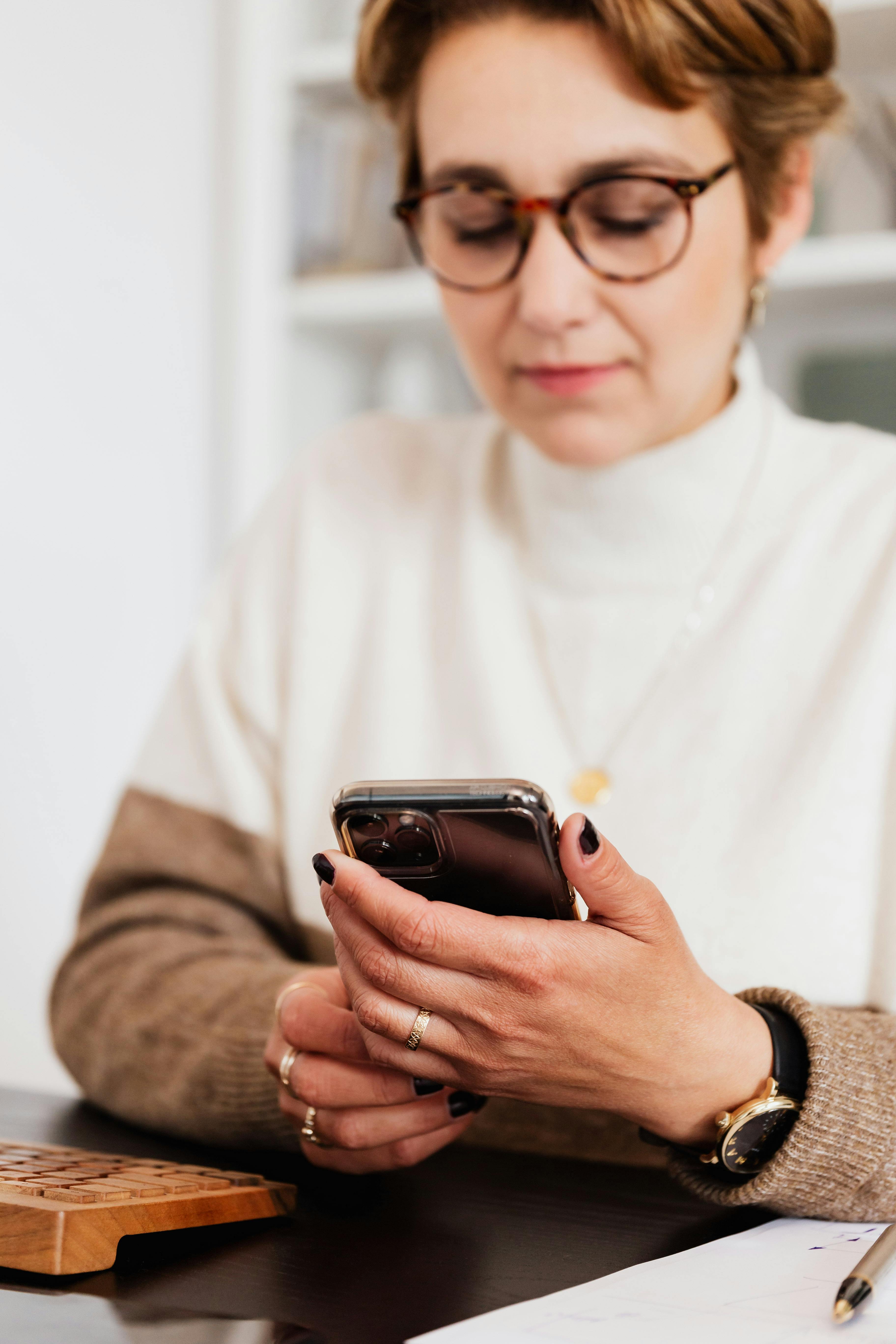 A woman reading messages on her smart phone | Source: Pexels