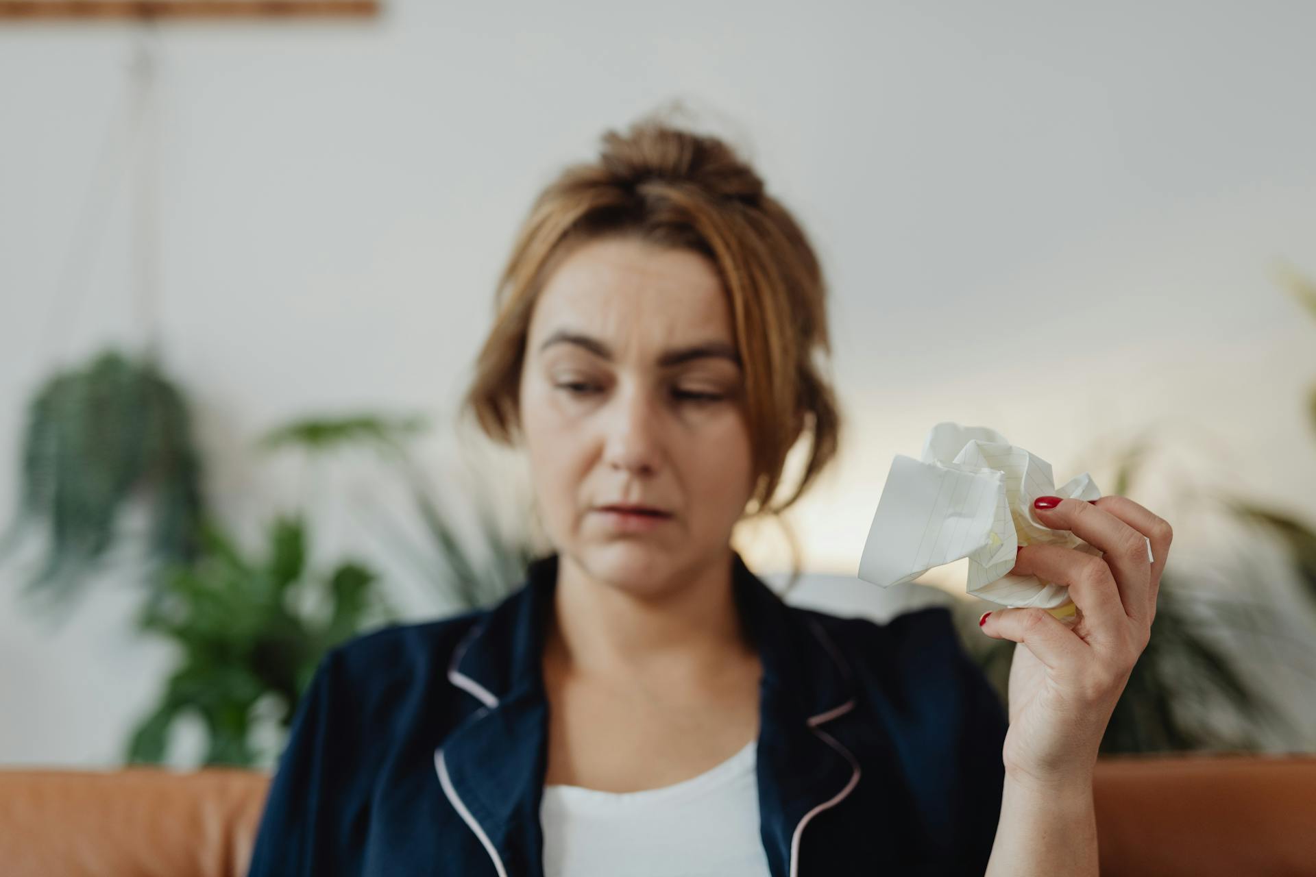 Woman holding a crumpled paper | Source: Pexels