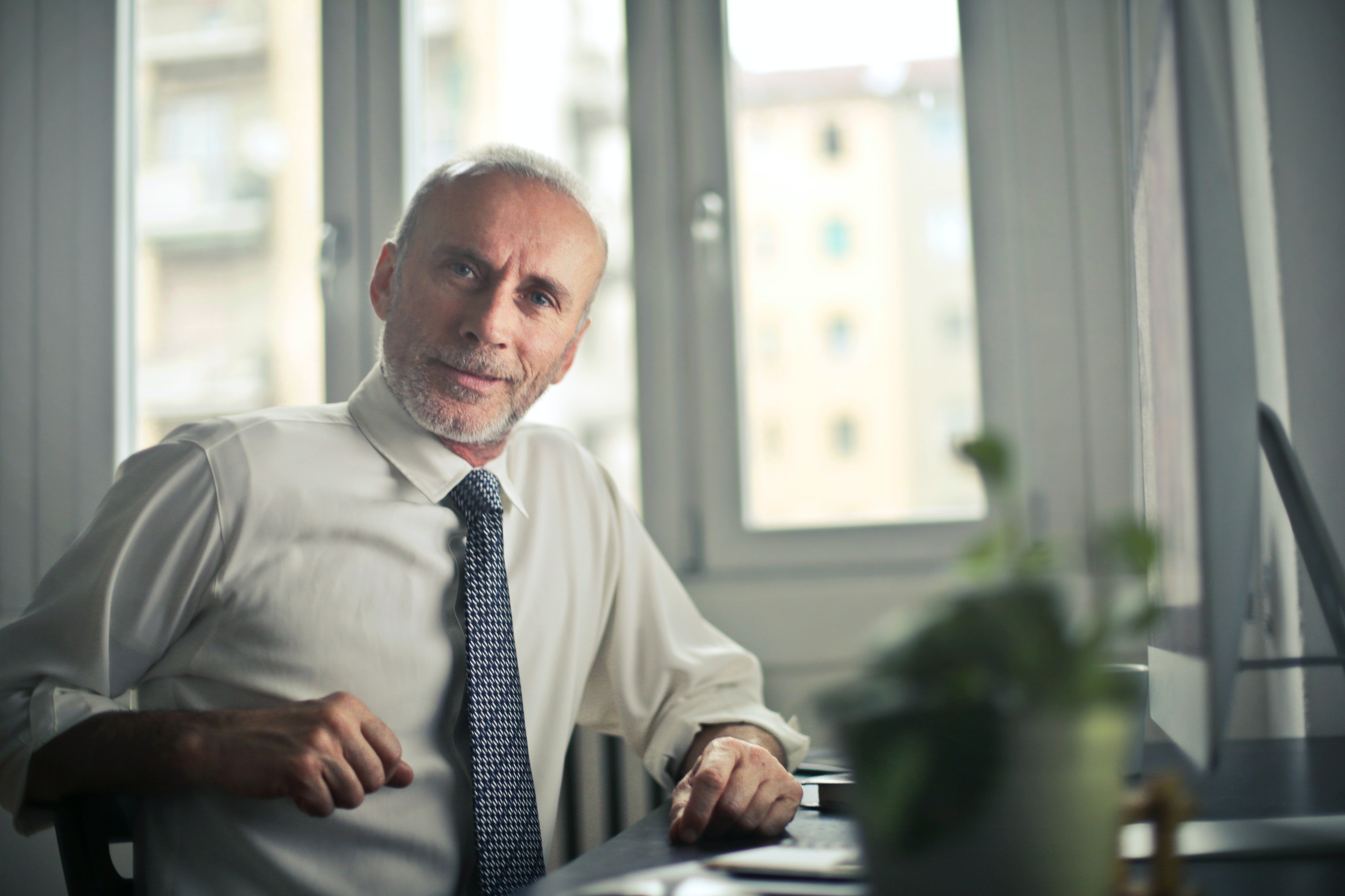 Man sitting on a chair beside a table | Photo: Pexels