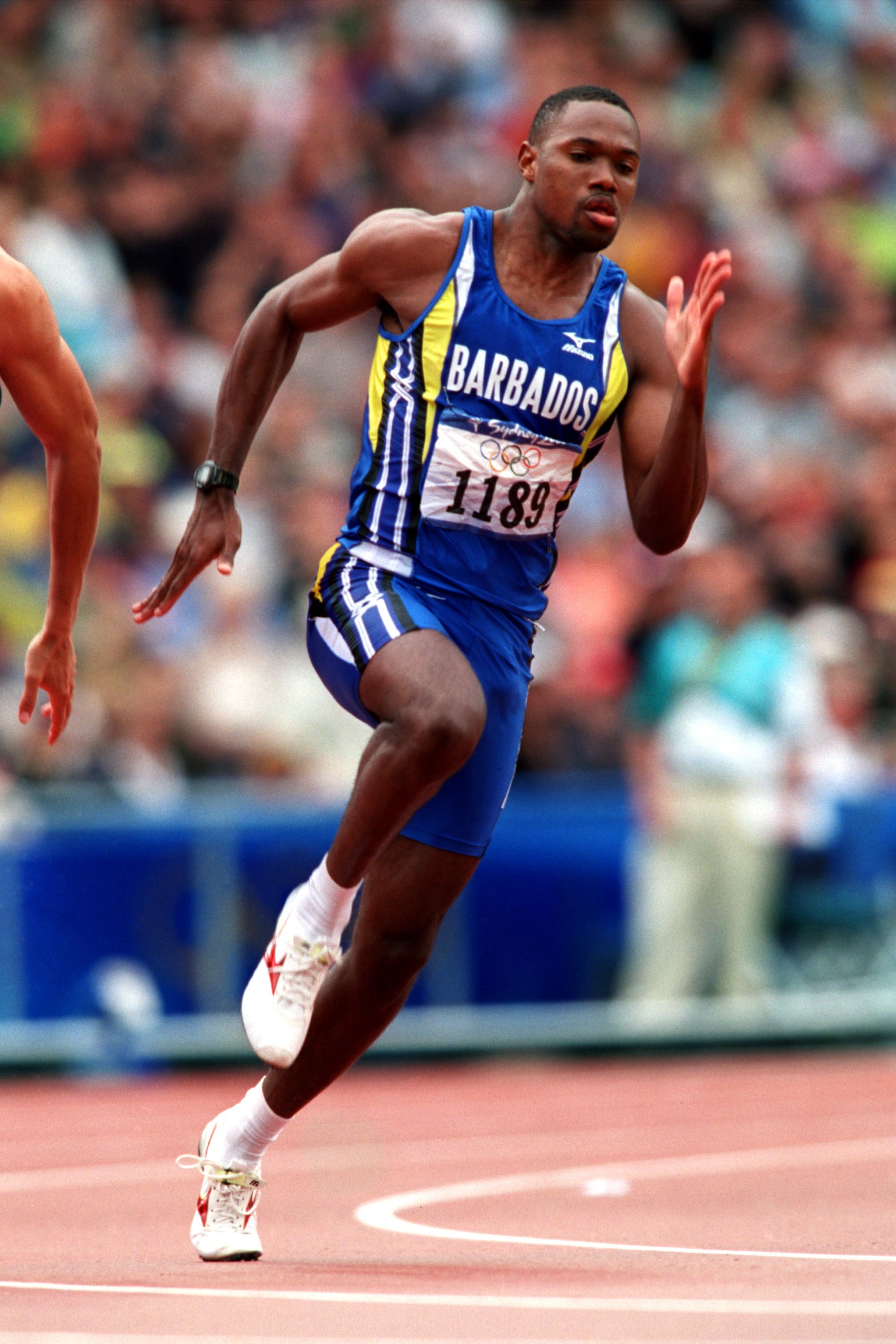 Barbados' Obadele Thompson sprinting to victory at Sydney's 2000 Olympics on September 27, 2000 | Photo: Tony Marshall/EMPICS/Getty Images