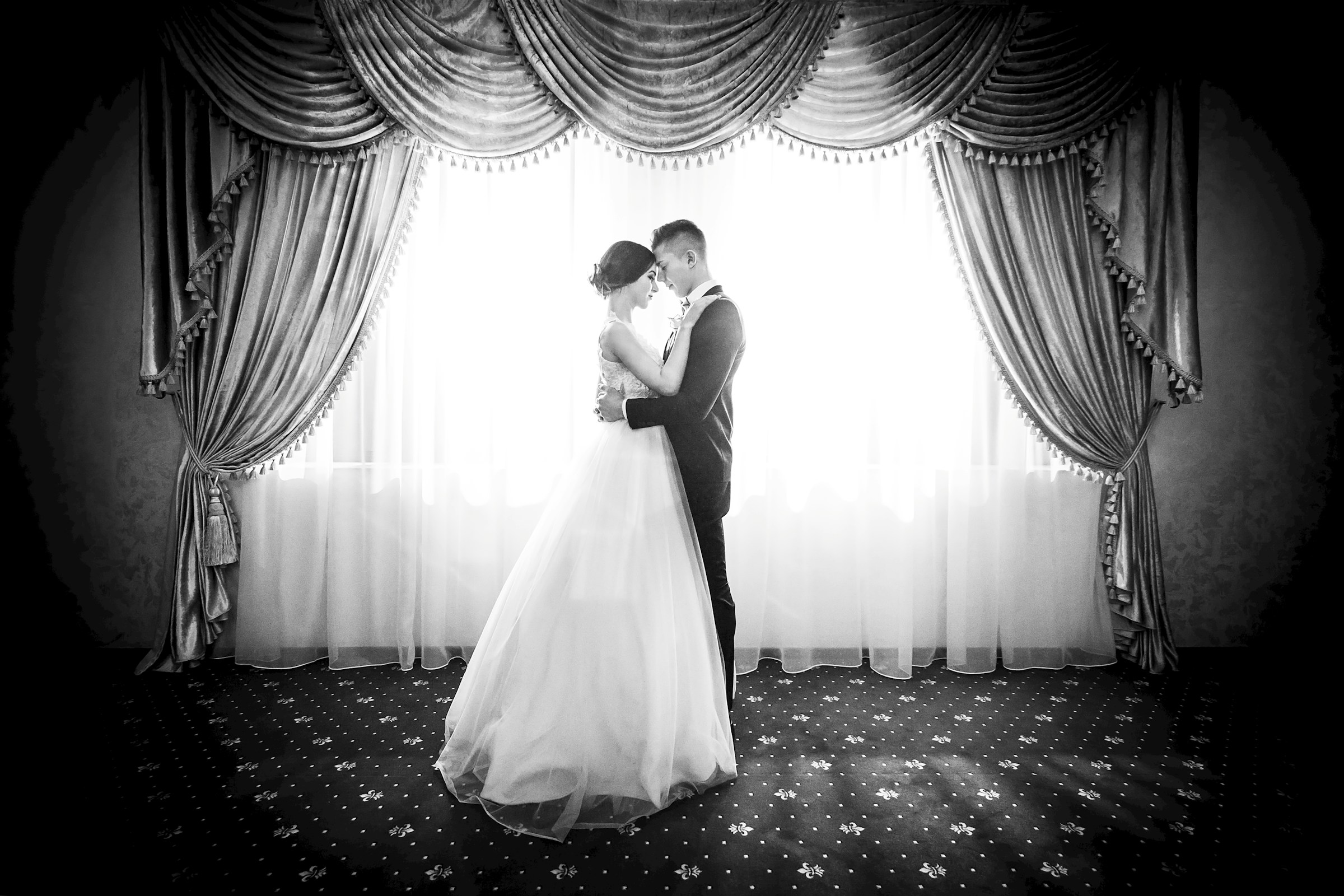 Grayscale shot of a bride and groom embracing each other | Source: Unsplash