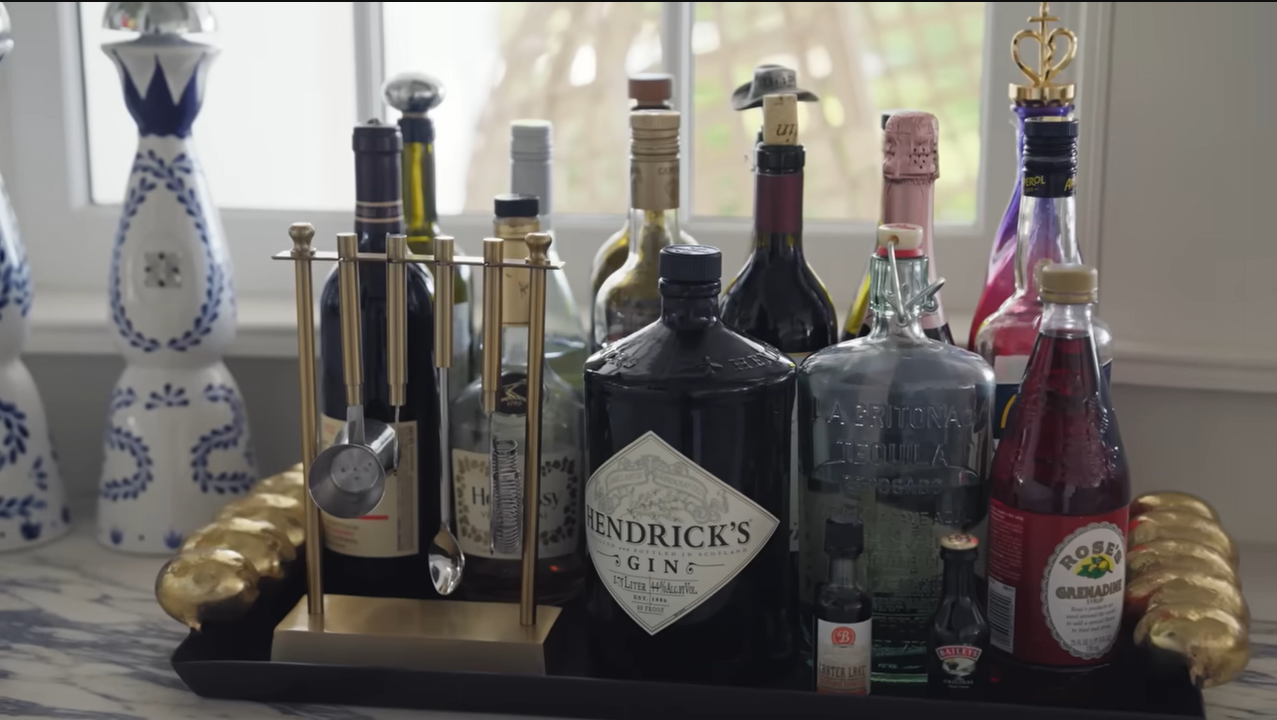A glamorous gold-trimmed tray holds everything from premium Hendrick's Gin to high-end mixers for entertaining guests. | Source: YouTube/@Archdigest