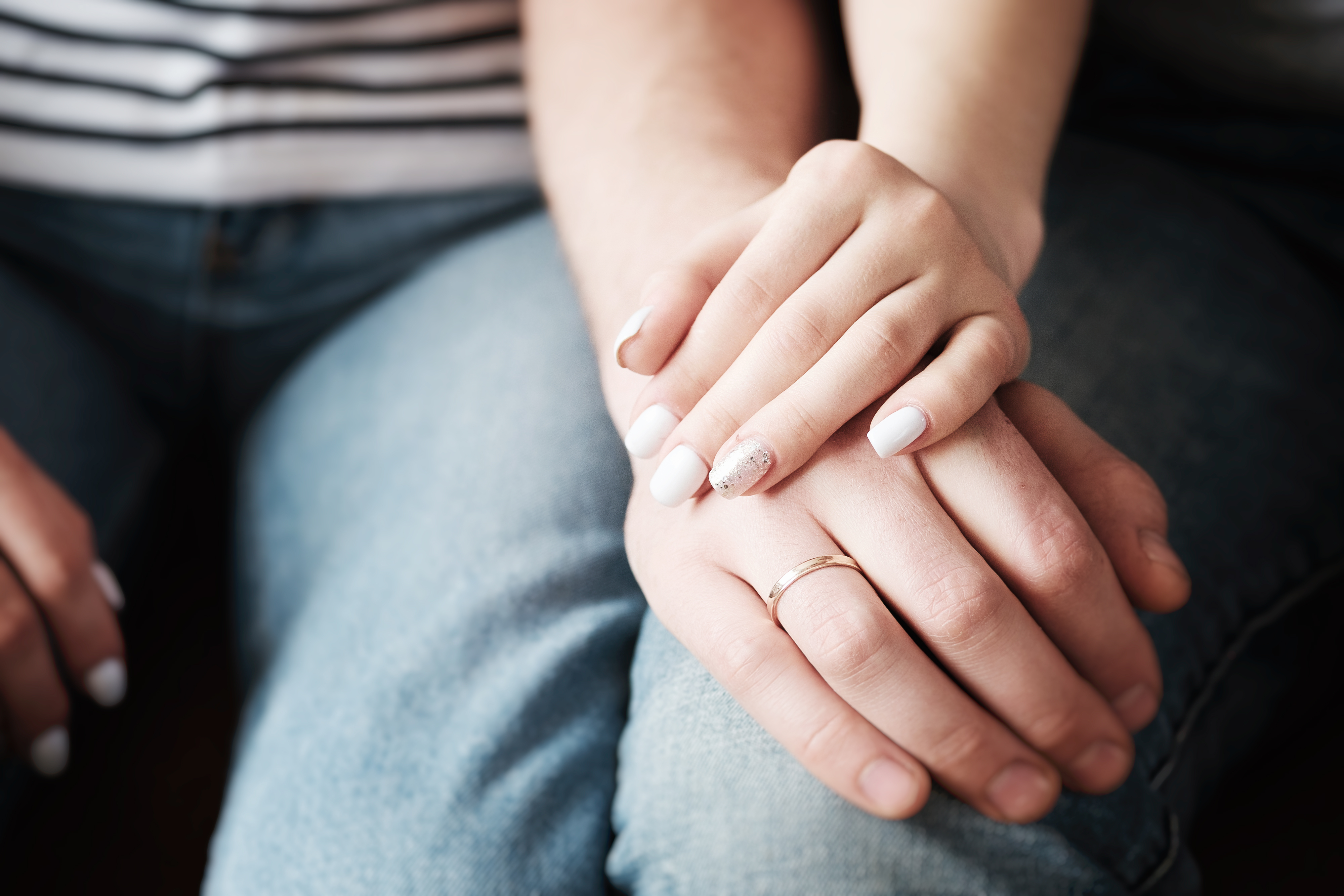 Couple holding hands as a sign of comfort and support | Source: Shutterstock