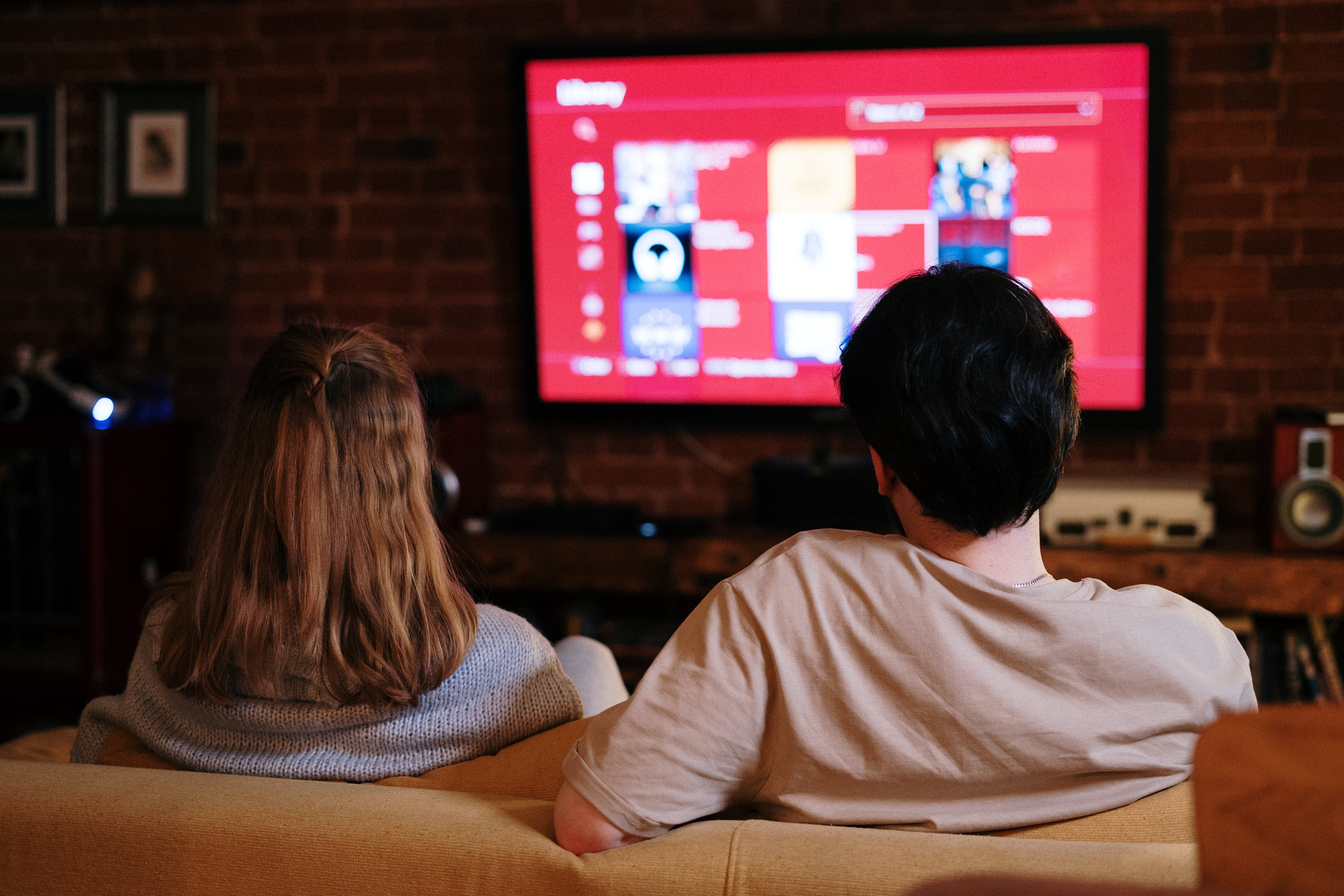 A man and a woman watching television together | Source: Pexels