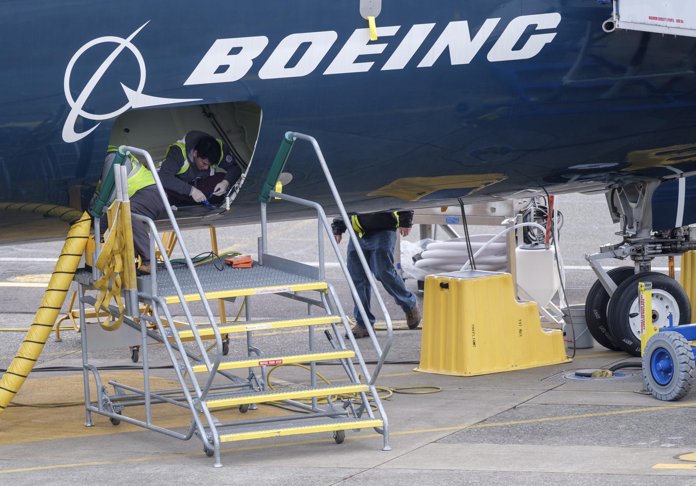 Employees work in the cargo hold of a Boeing 727 MAX 9 test plane outside the company's factory, on March 14, 2019 | Source: Getty Images