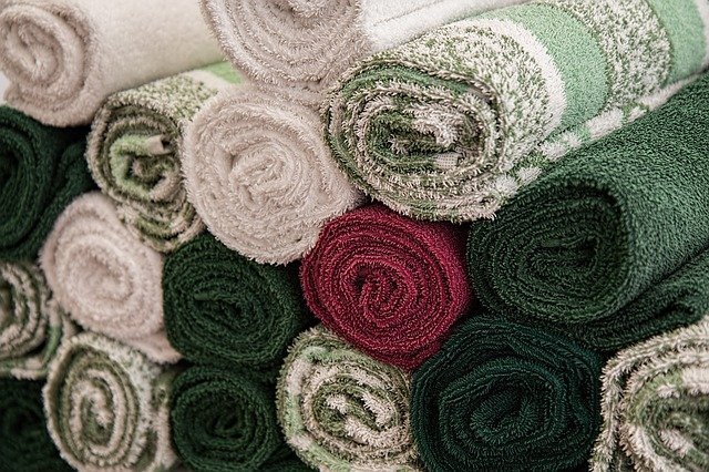 Soft-looking towels neatly rolled and arranged. | Source: Pixabay