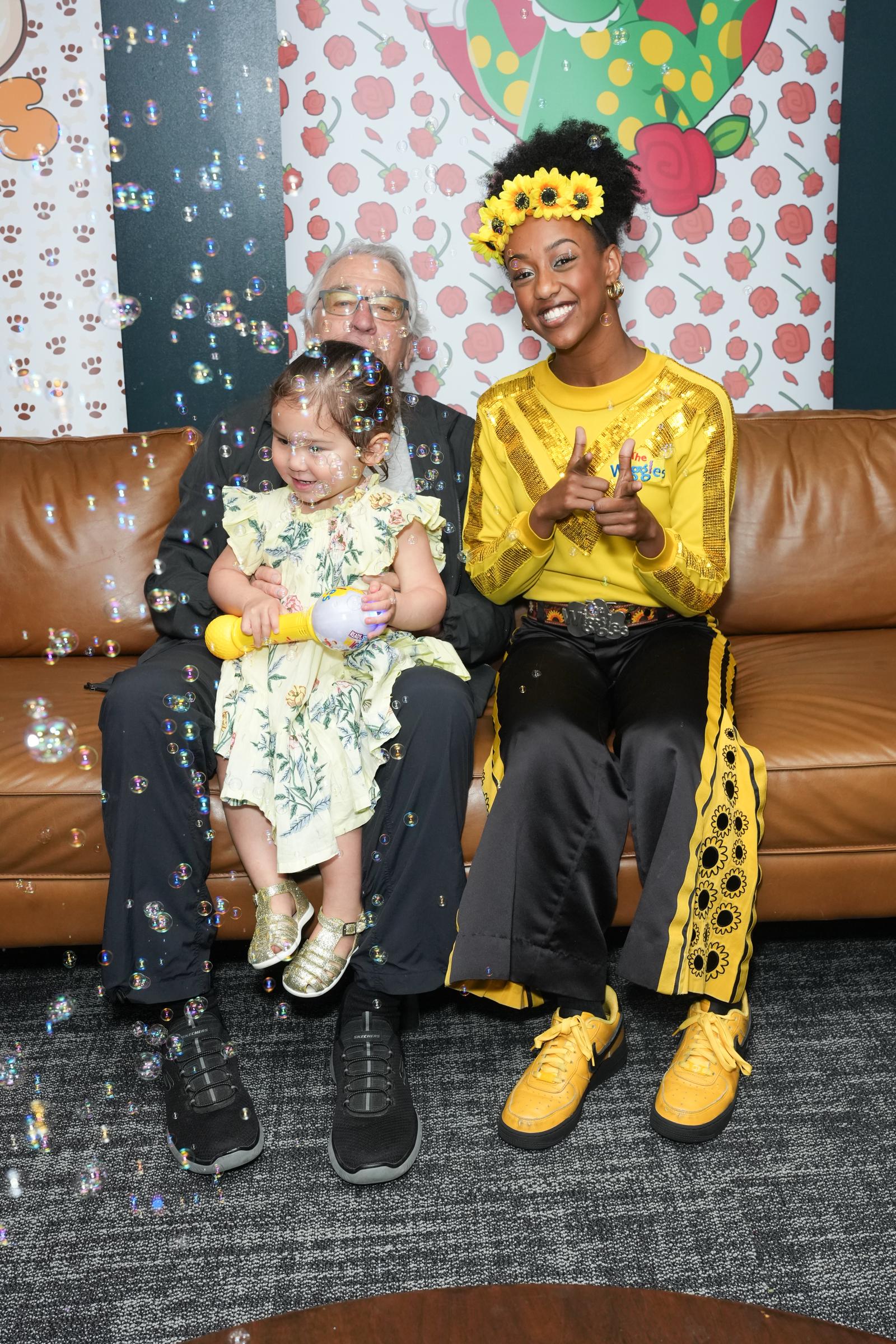 Robert De Niro and Gia Virginia Chen-De Niro sitting together with Tsehay Hawkins from The Wiggles during the Kings Theatre event | Source: Getty Images