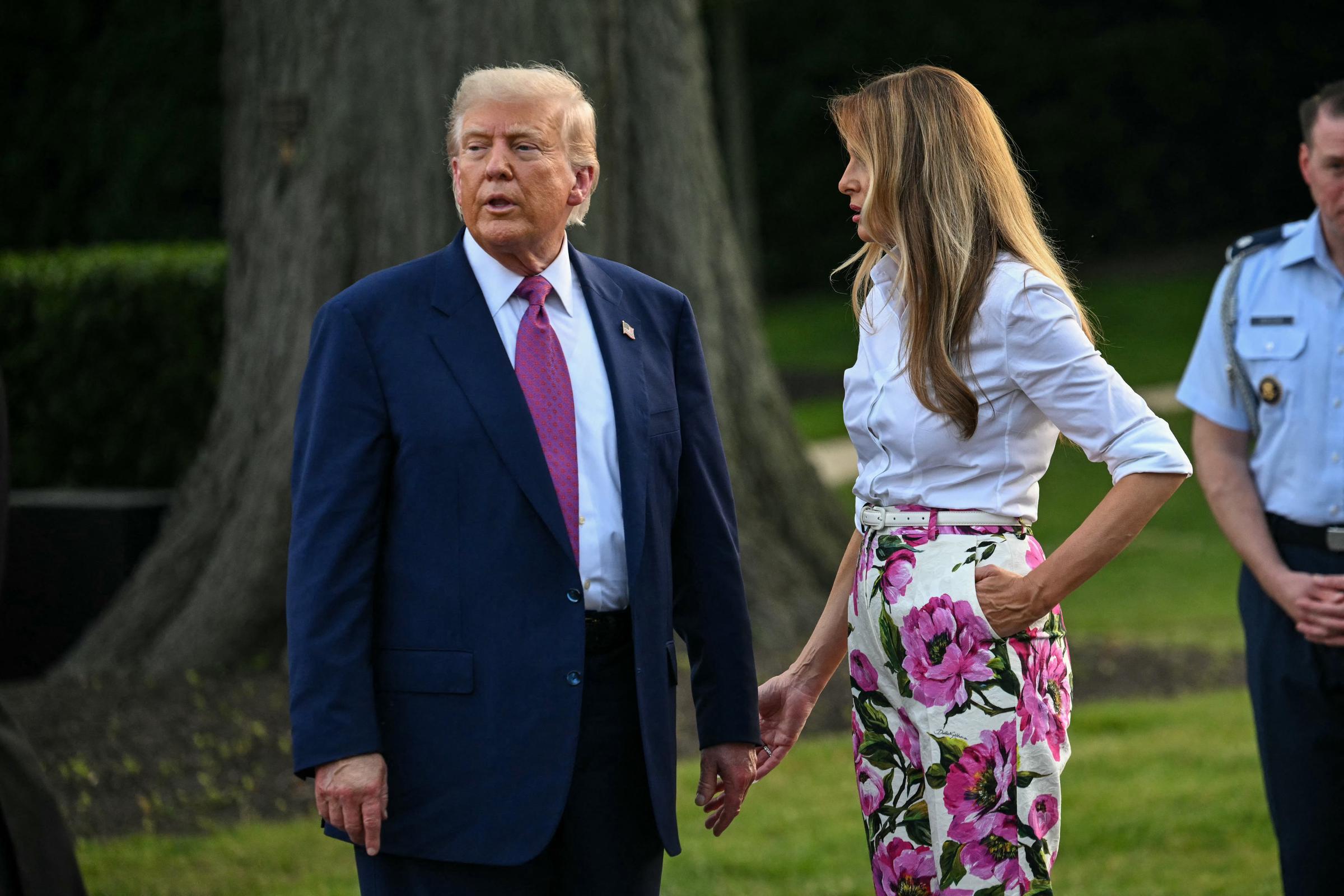 On the South Lawn, Donald and Melania Trump pause for conversation during the event. Surrounded by security and guests, the two appear engaged with the setting and each other in a more relaxed part of the evening.