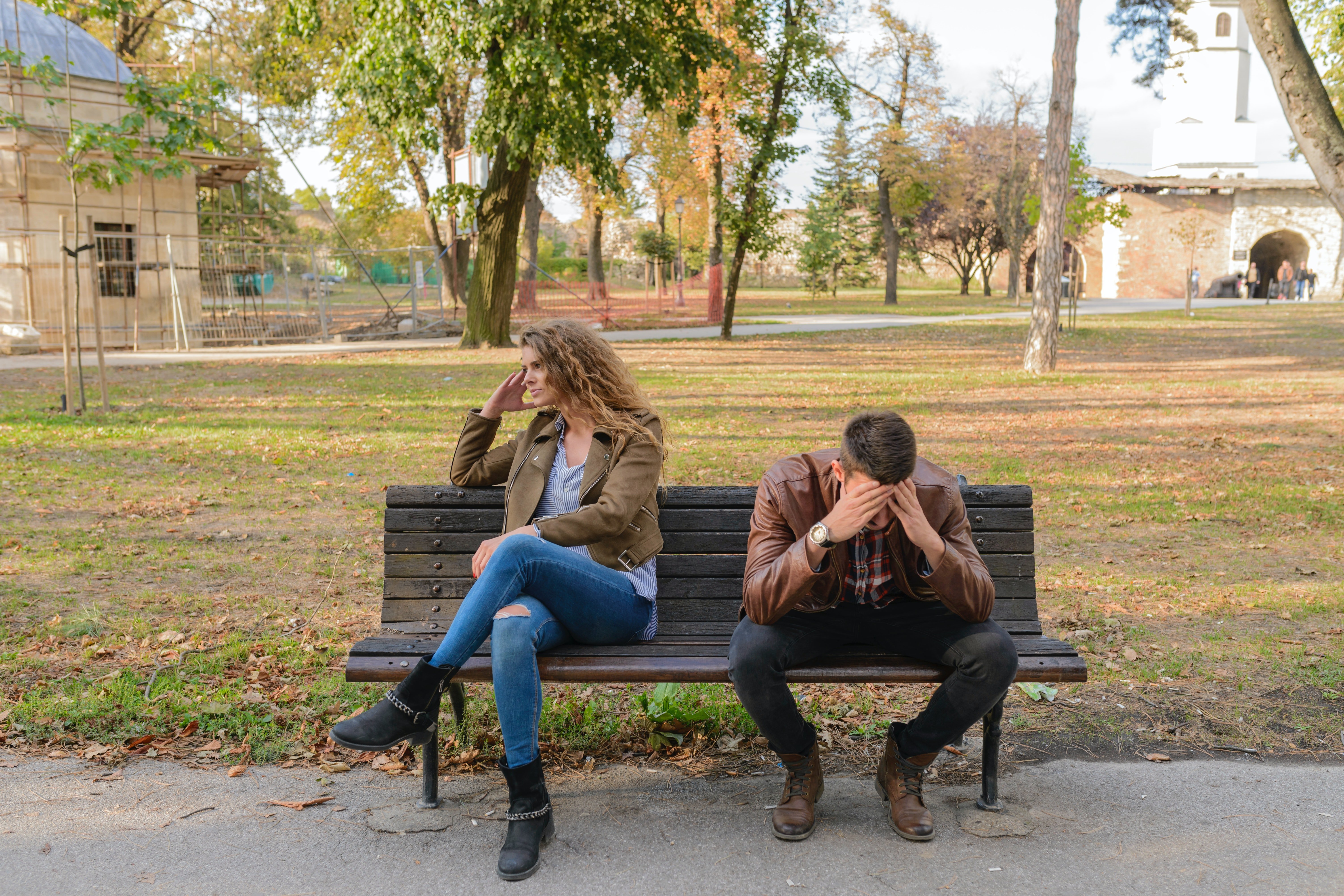 Angry couple sits on a park bench outside | Photo: Pexels