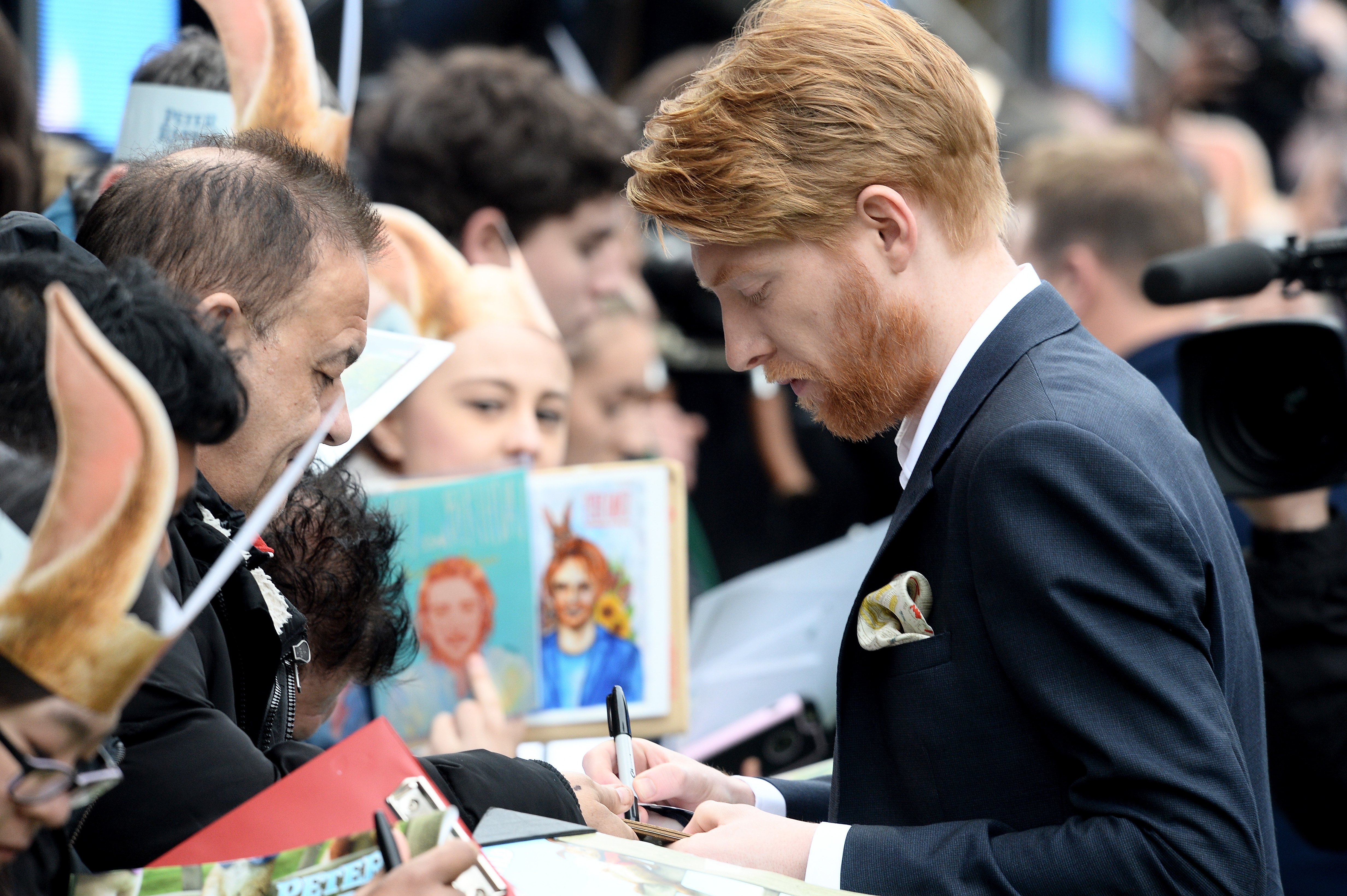 Domhnall Gleeson signing autographs for fans at the premiere of "Peter Rabbit" on March 11, 2018, in London | Source: Getty Images
