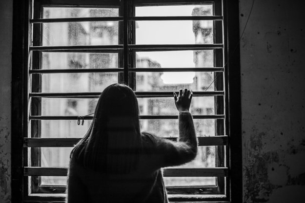 Sad woman looking out of a window. | Photo: Shutterstock