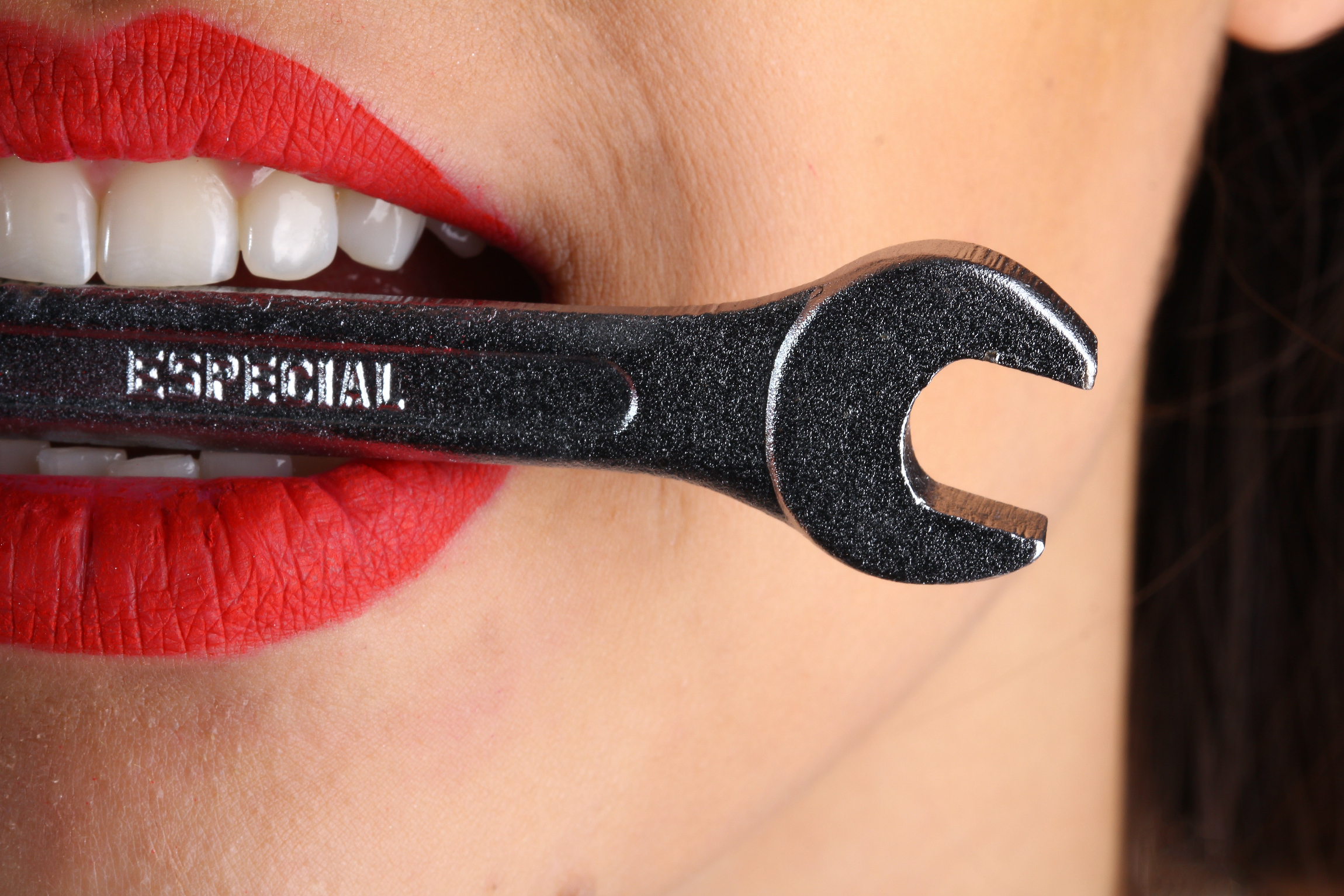 An individual holding a wrench between their teeth. | Source: Pexels