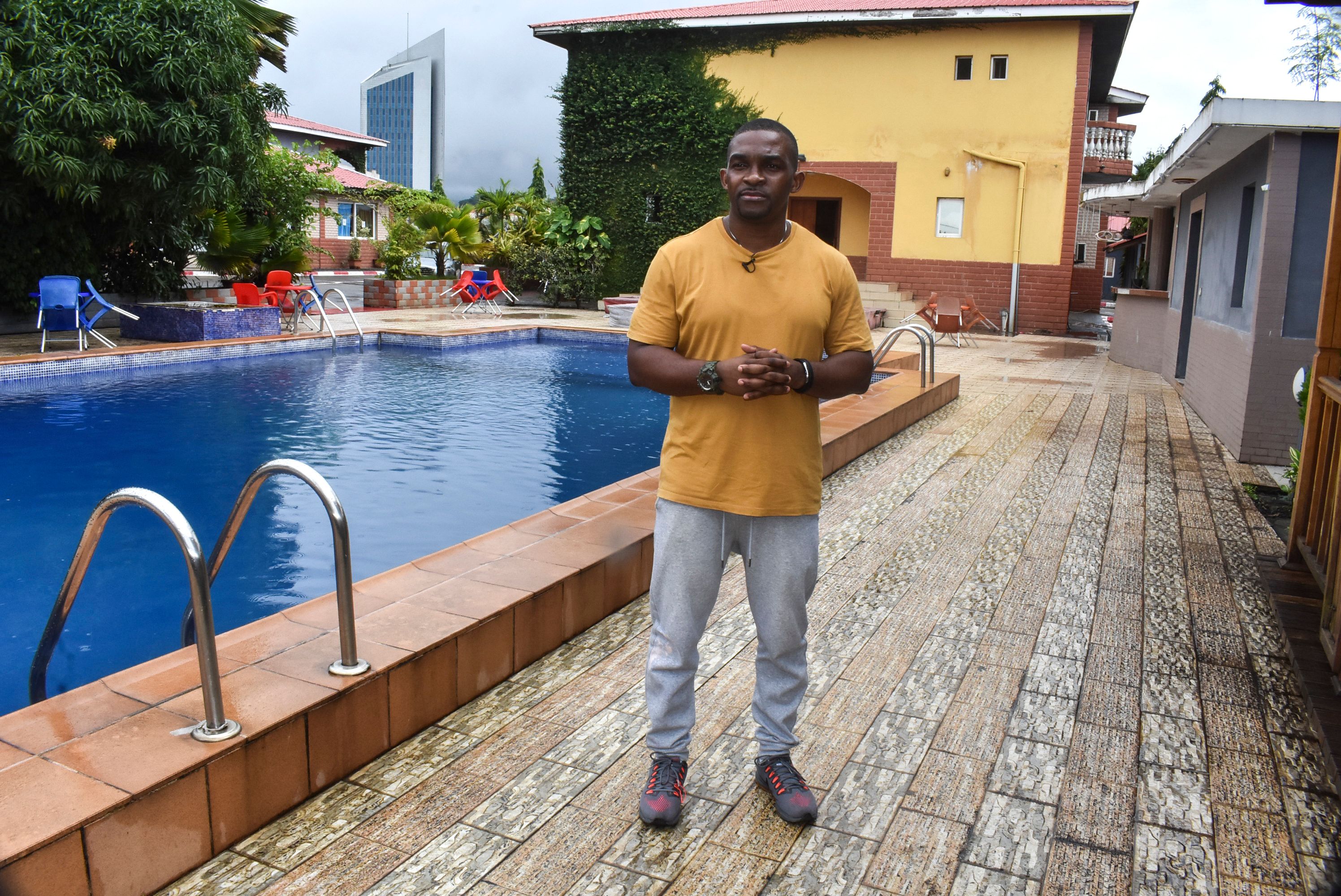 Eric Moussambani speaks with AFP while standing next to a 12m long swimming pool, similar to the one he used to train while preparing for the Olympics, at the CHN Flat-Hotel in Malabo on September 12, 2020 | Source: Getty Images