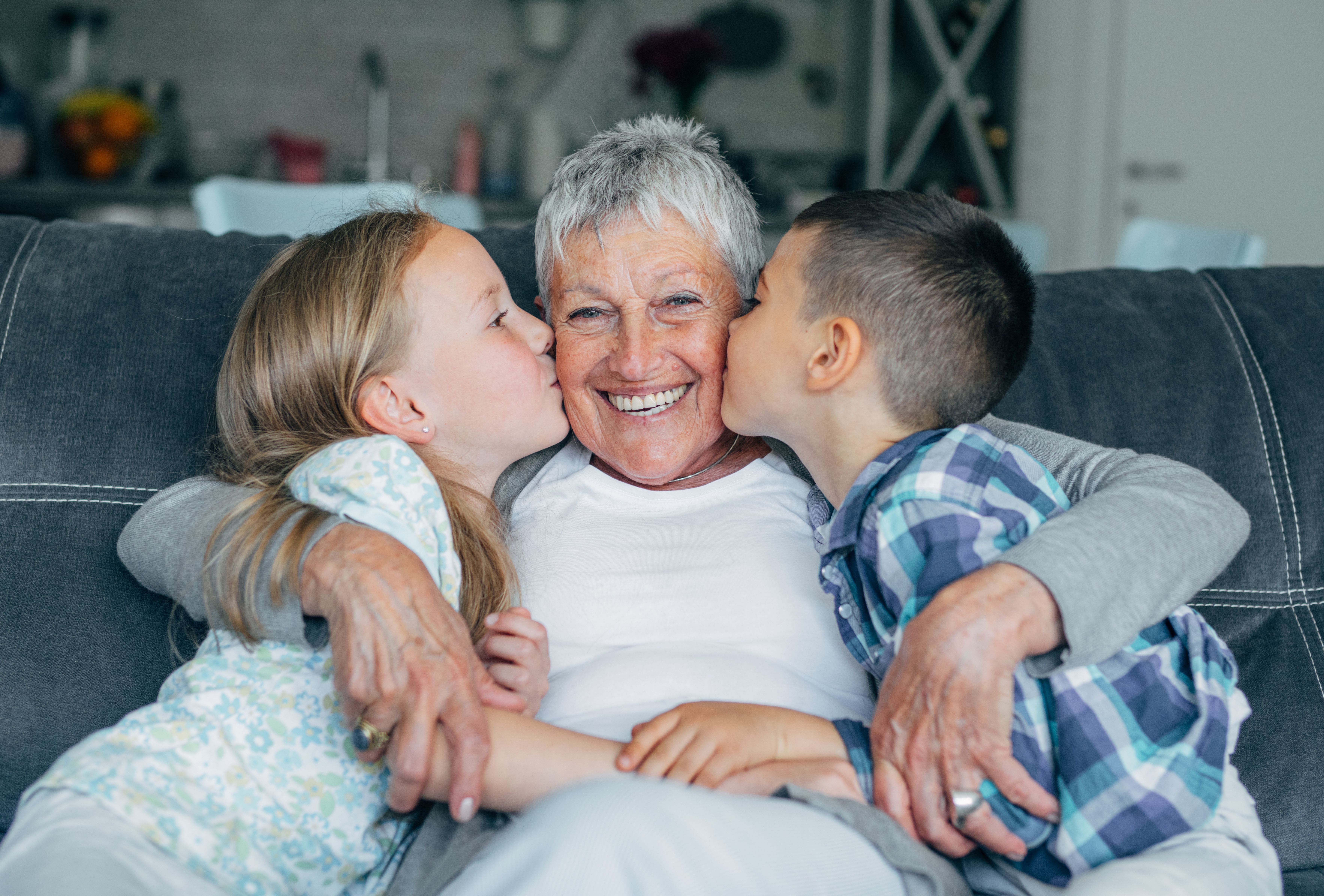 Grandkids kissing their grandmother on the cheek | Source: Getty Images