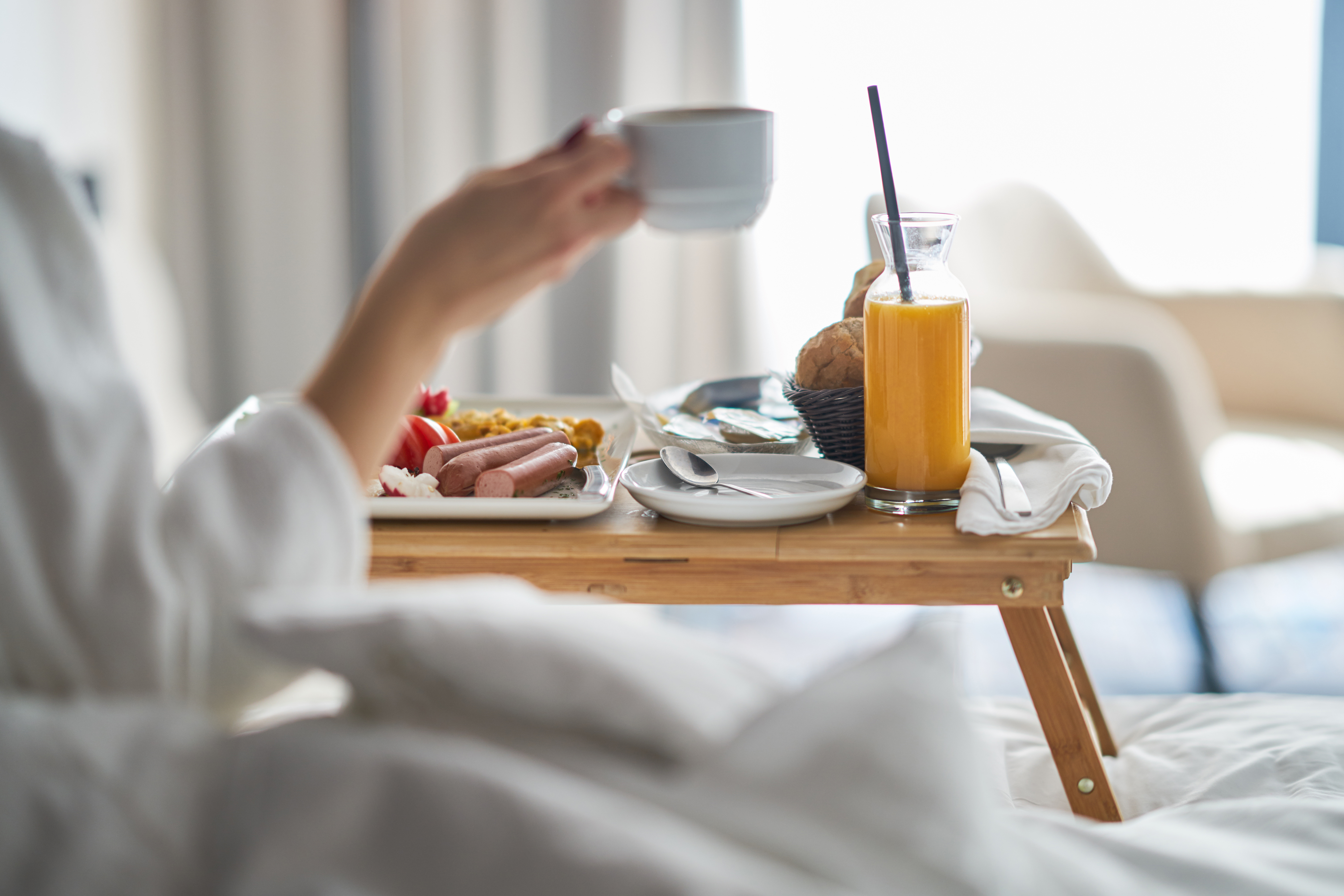 A woman having breakfast in a cozy hotel room | Source: Shutterstock
