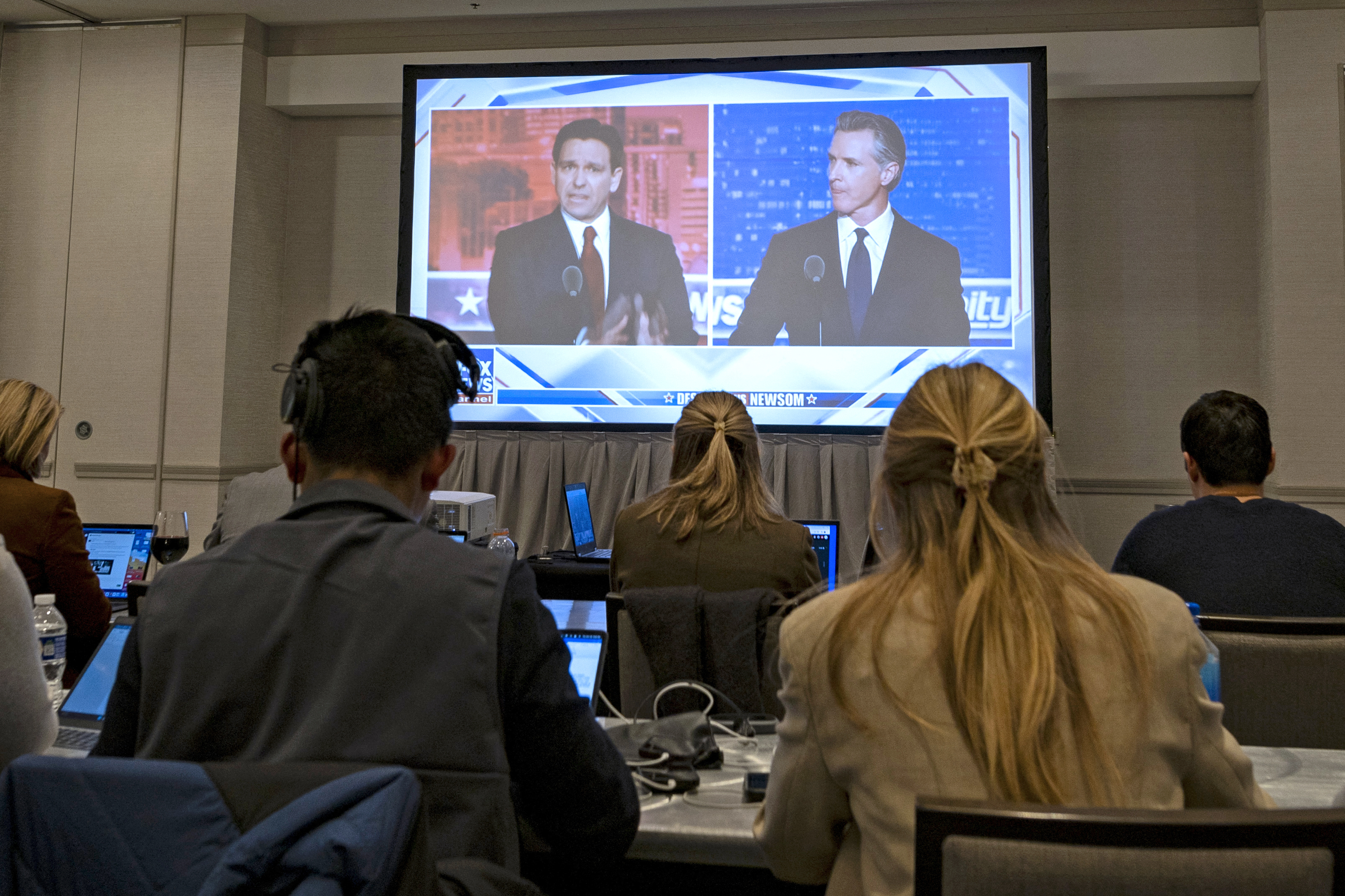 Florida Governor Ron DeSantis and California Governor Gavin Newsom appear onscreen from the press room during a Fox News debate in Alpharetta, Georgia, on November 30, 2023. | Source: Getty Images