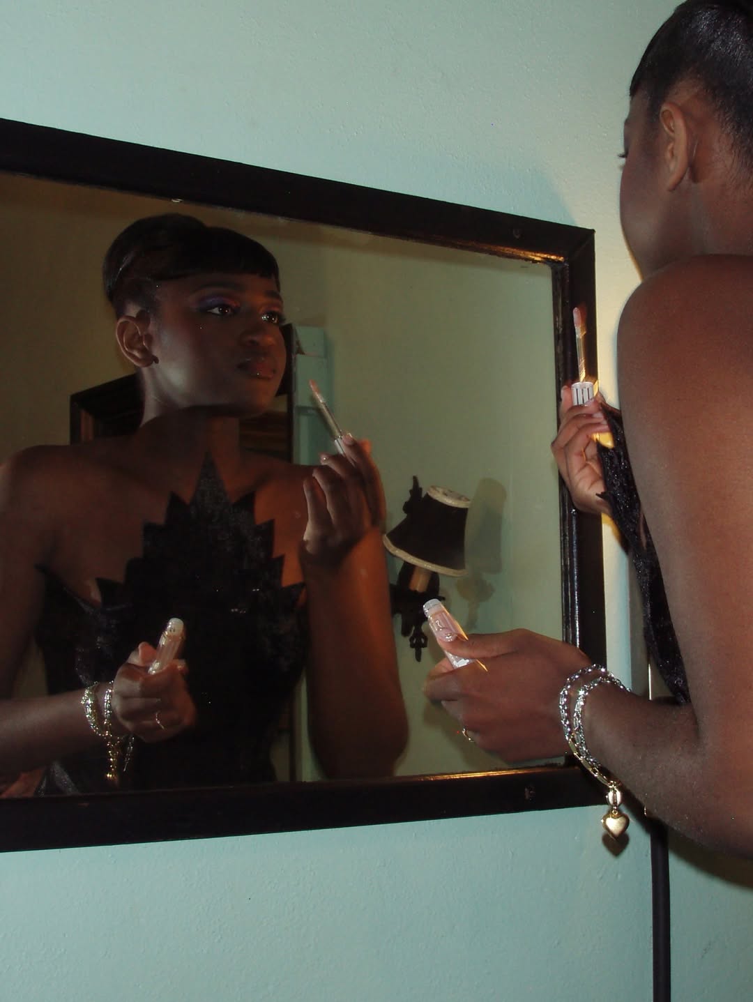 Zaya Wade applies makeup while looking into a mirror, offering a behind-the-scenes glimpse of her preparation before the Translatable Ball. | Source: Instagram/zayawade