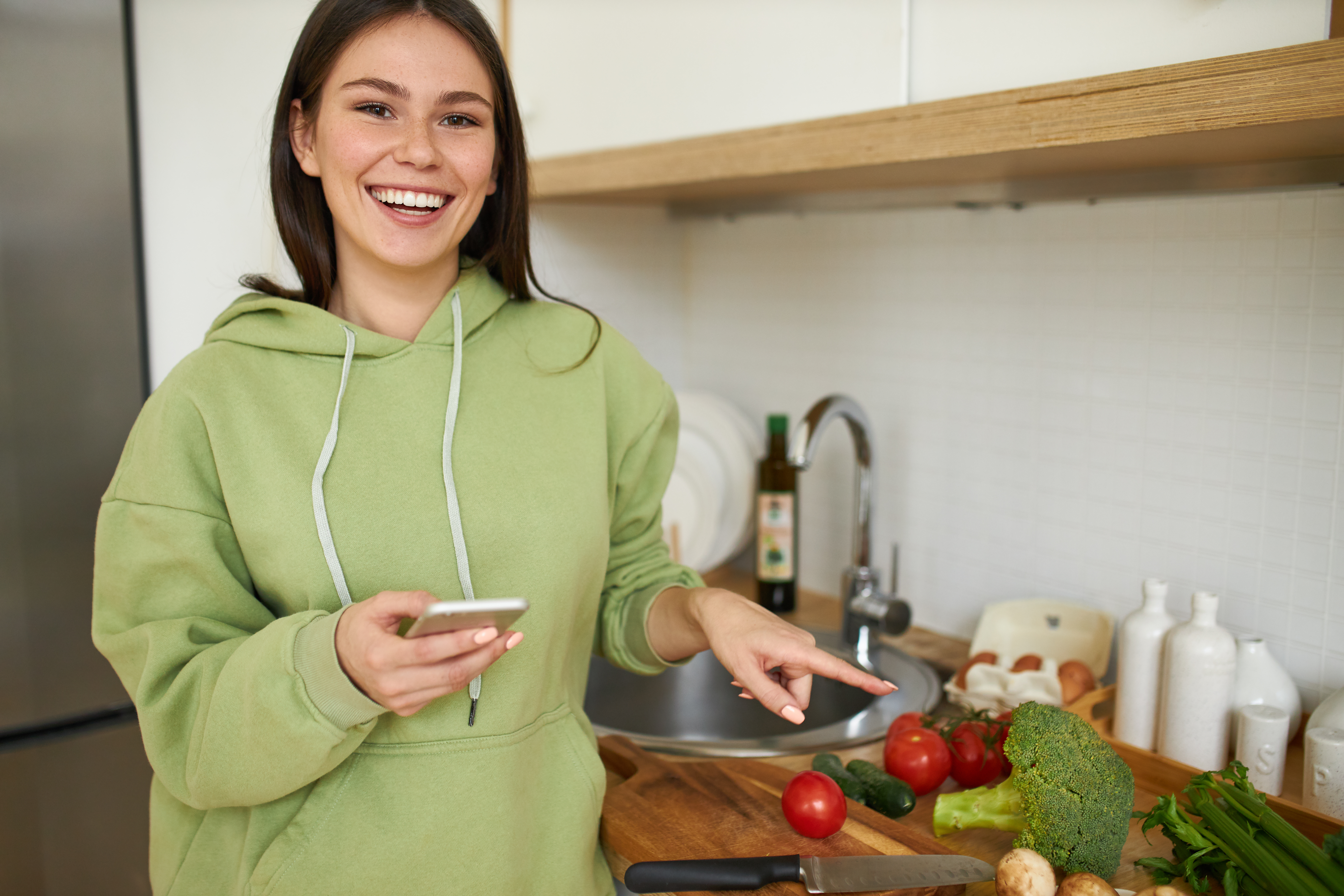 A young woman pointing at food in the kitchen | Source: Shutterstock