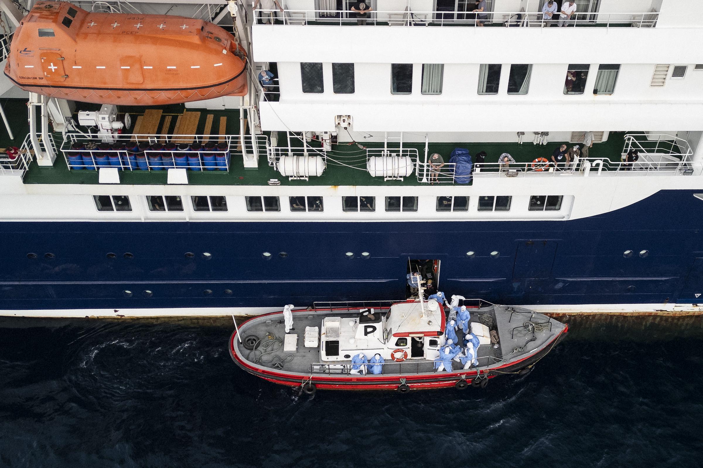 This aerial view shows health personnel assisting patients onto a boat from the cruise ship MV Hondius, while stationary off the port of Praia, the capital of Cape Verde, on May 6, 2026 | Source: Getty Images