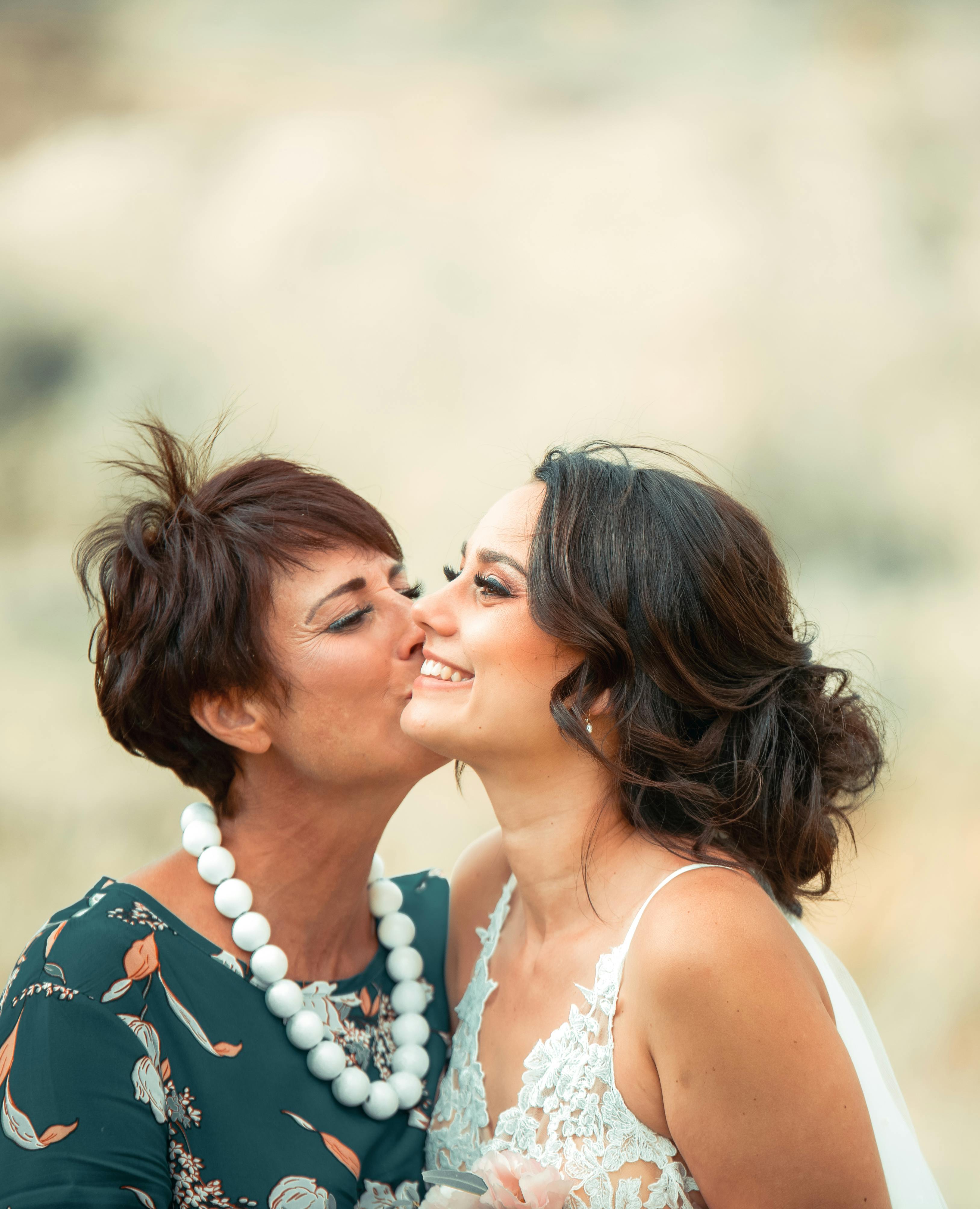 A woman kissing a bride's cheek | Source: Pexels