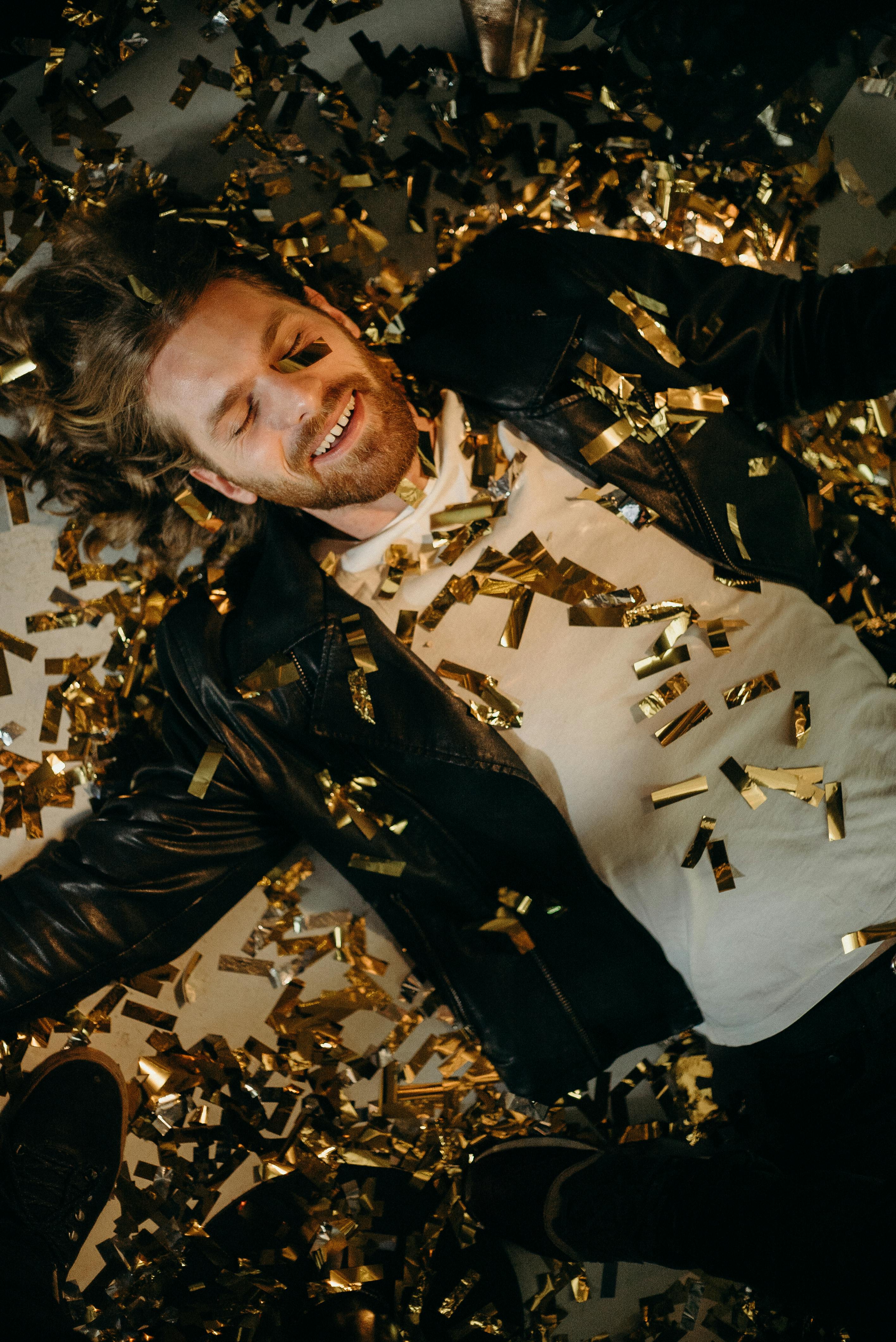 A man lying in confetti | Source: Pexels