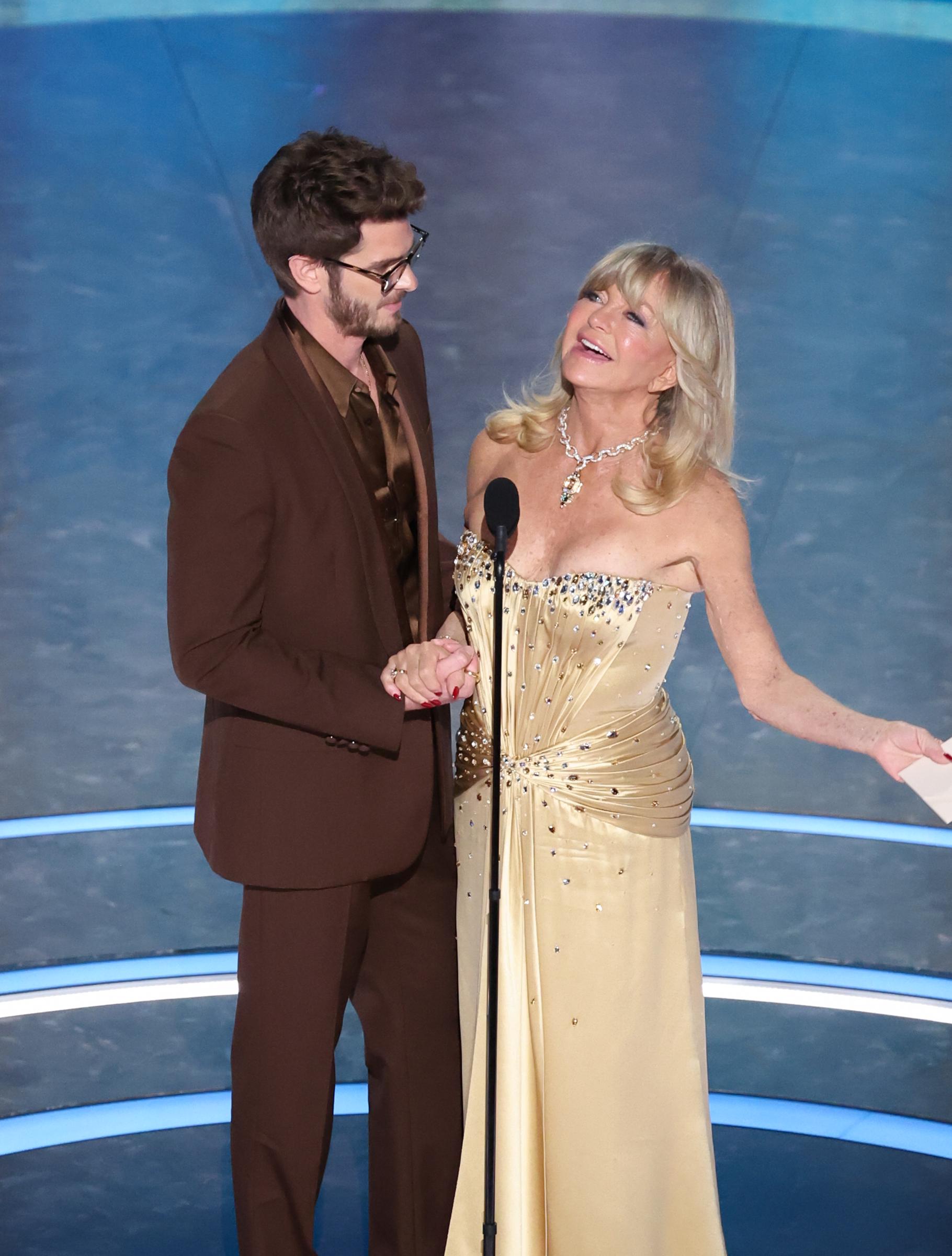 Goldie Hawn speaks while Andrew Garfield listens at the 97th Academy Awards | Source: Getty Images