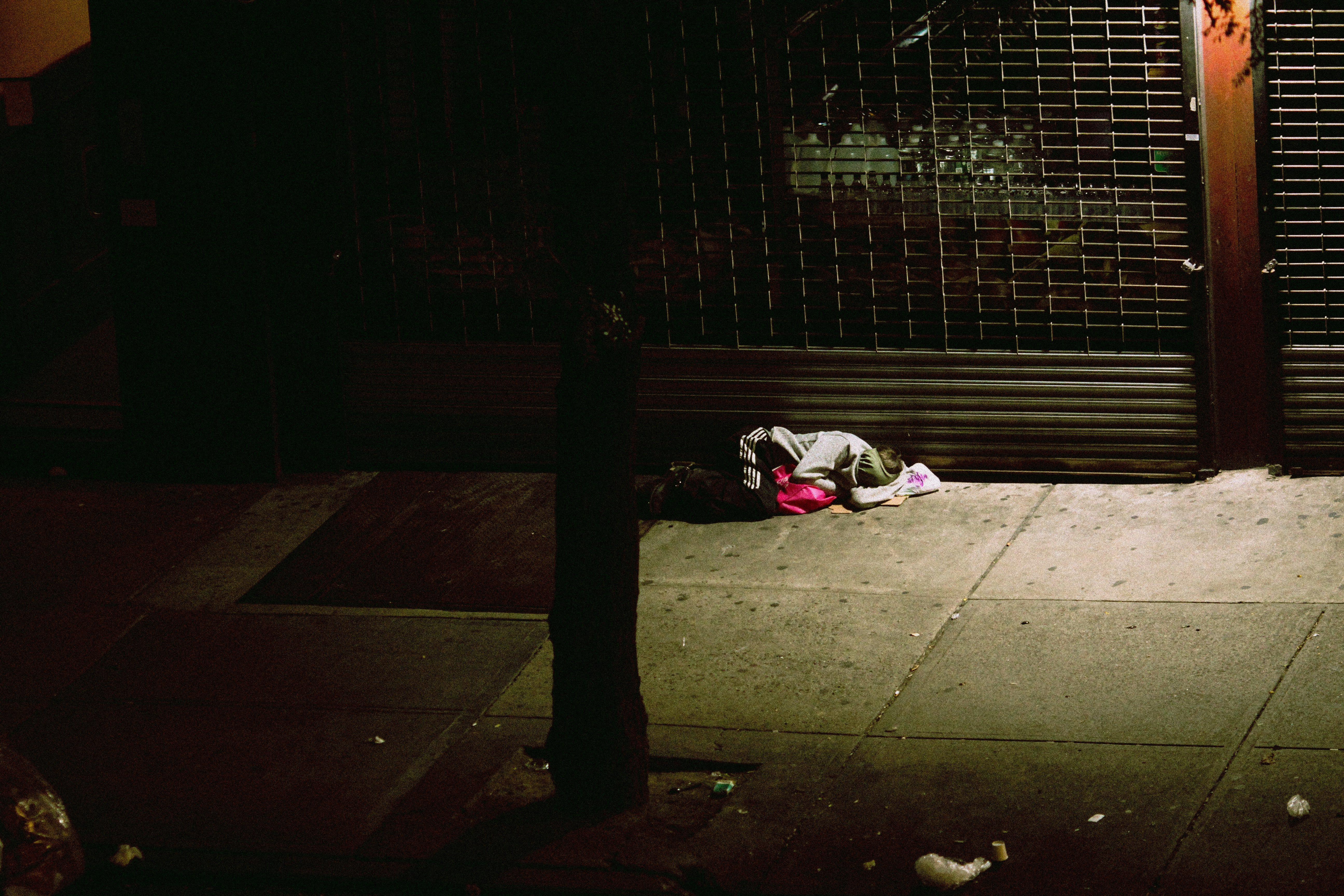Una persona duerme en el suelo, envuelta en cobijas. | Foto: Unsplash